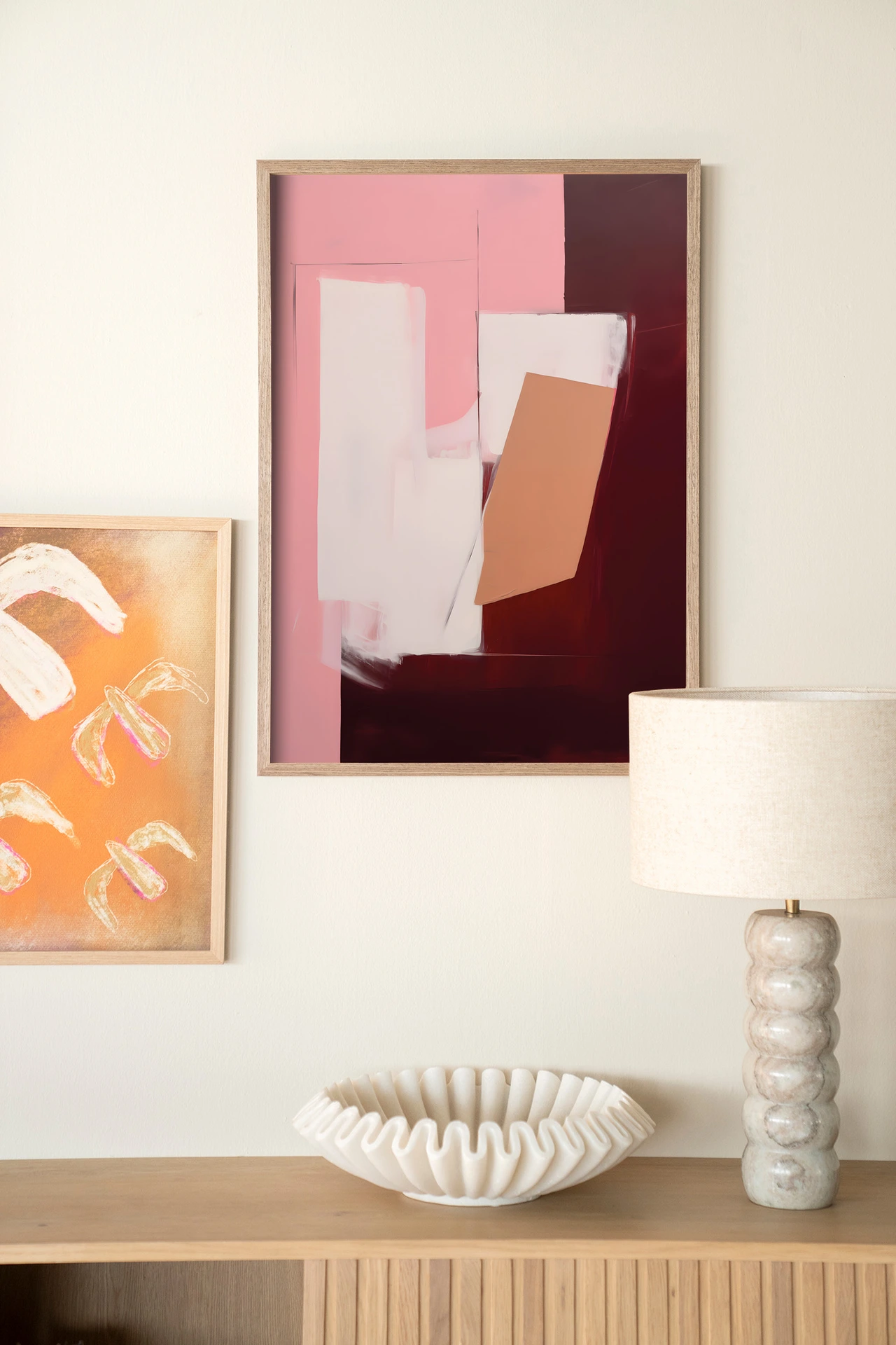 Wandteppich Red Fields - Urban Cotton hängt an einer weißen Wand über einem Sideboard aus Holz, mit einer Lampe und Schale daneben