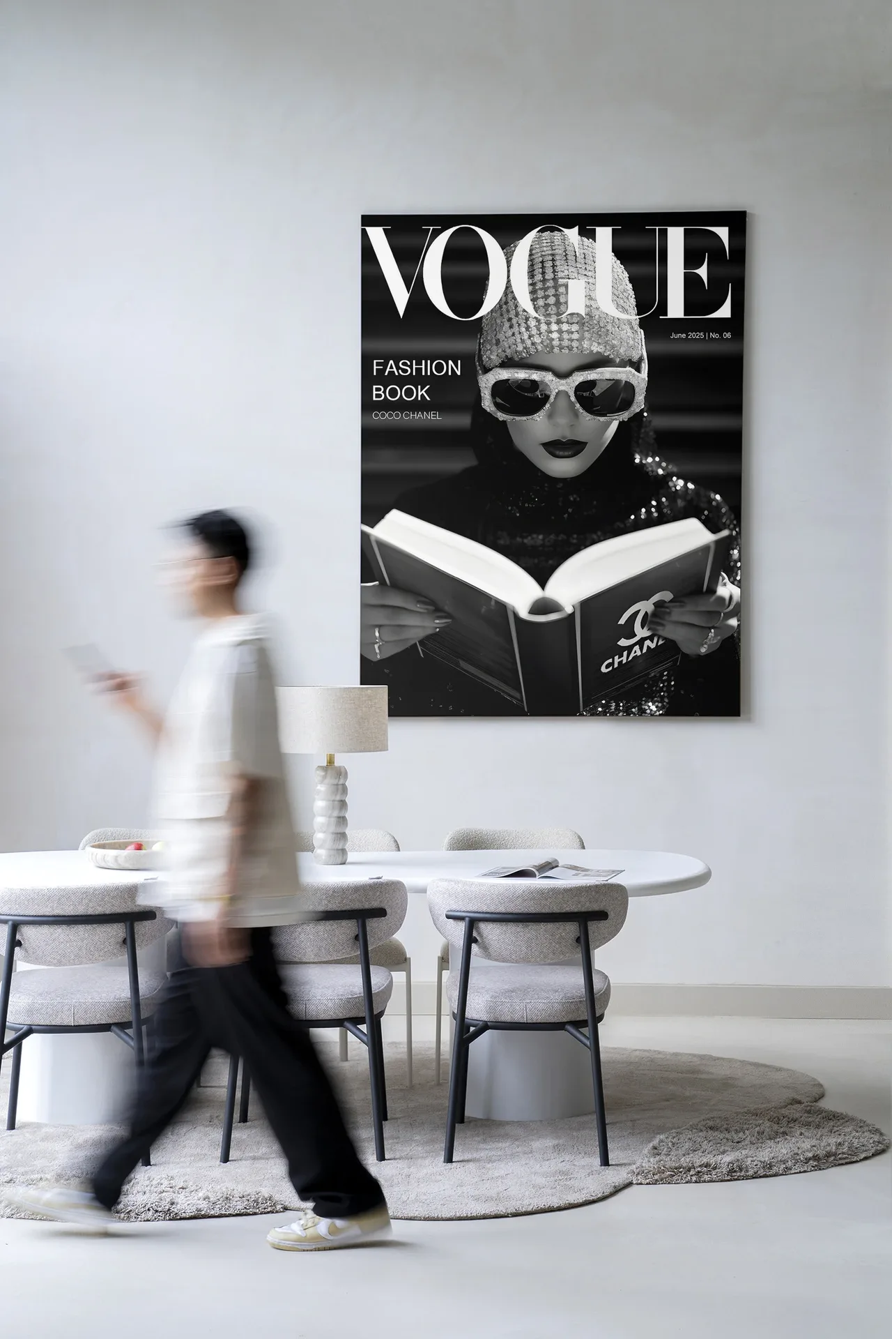 Wandteppich Fashion Book Black - Urban Cotton hängt an einer weißen Wand über einem Esstisch mit Stühlen