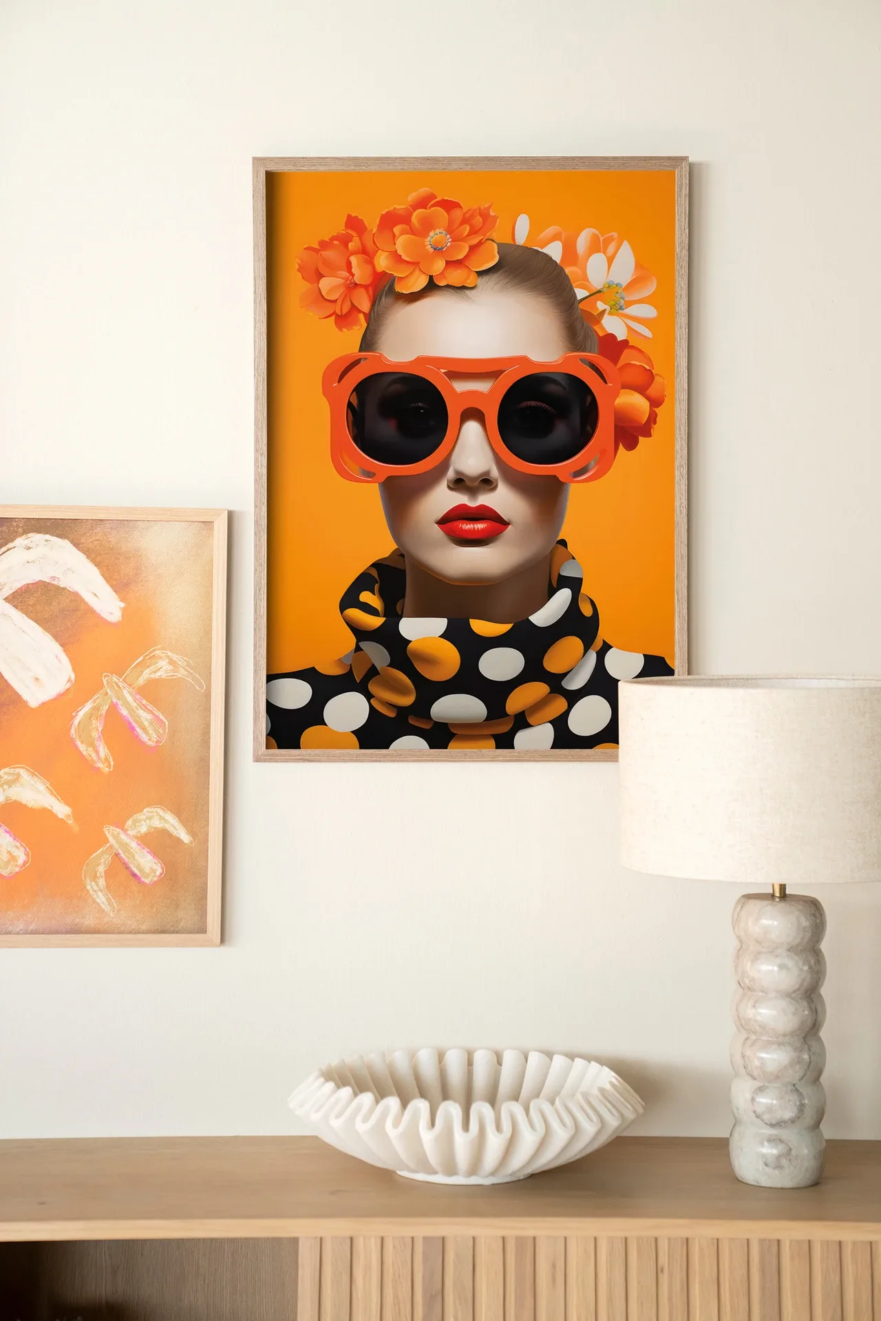 Wandteppich Orange Flower - Urban Cotton hängt an einer weißen Wand, mit Lampe und Schale auf einem Sideboard aus Holz