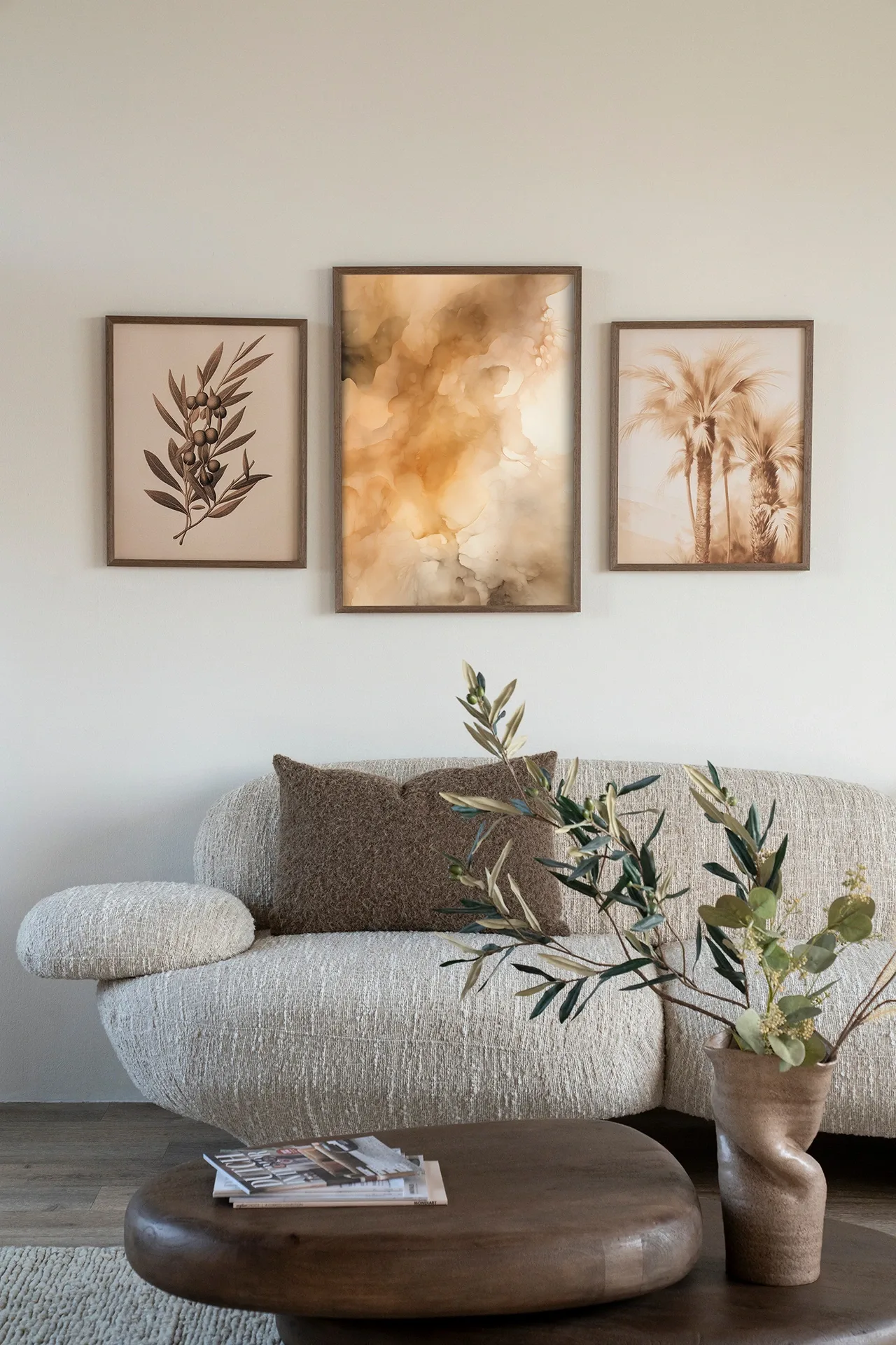 Drei Wandteppiche, darunter Wandteppich Rusty Clouds, hängen über einem beigen Sofa mit braunen Kissen und einem Couchtisch - Urban Cotton