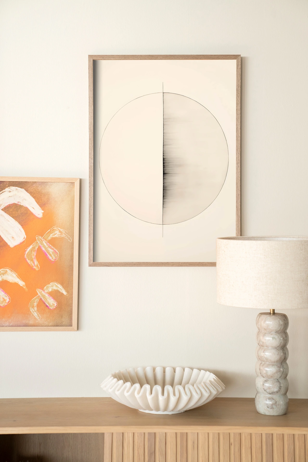 Wandteppich Nara - Urban Cotton hängt an einer hellen Wand über einem Sideboard aus Holz mit Dekoration