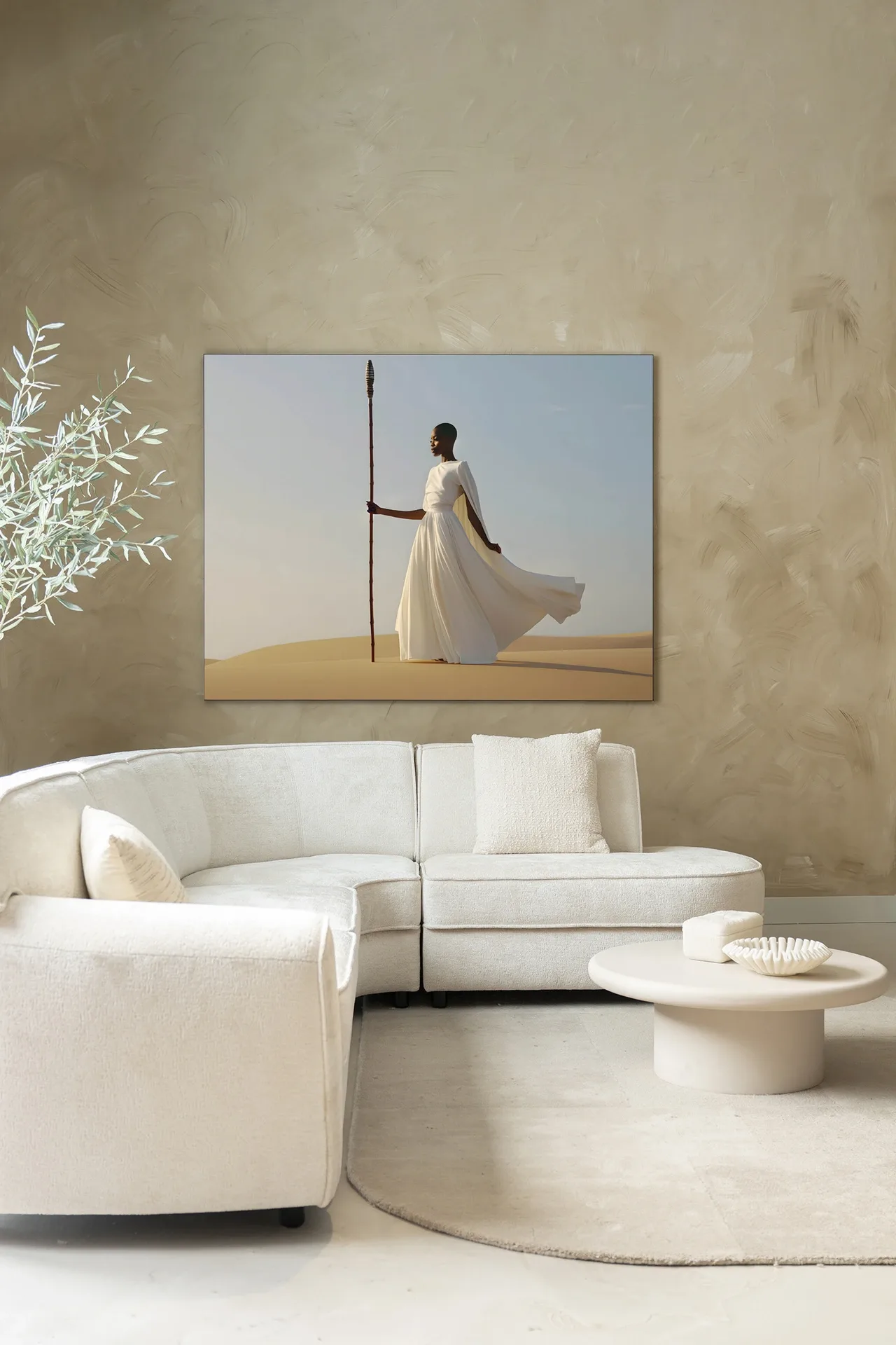 Wandtuch Warrior In White - Urban Cotton hängt über einem weißen Ecksofa mit einem runden Couchtisch davor