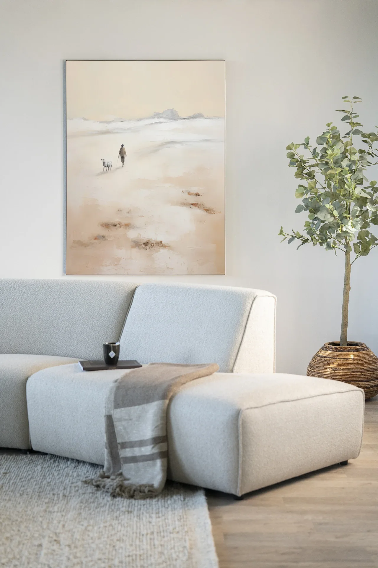 Wandteppich Shepherd Vertikal von Urban Cotton hängt über einem hellgrauen Sofa mit Plaid und einer Pflanze daneben