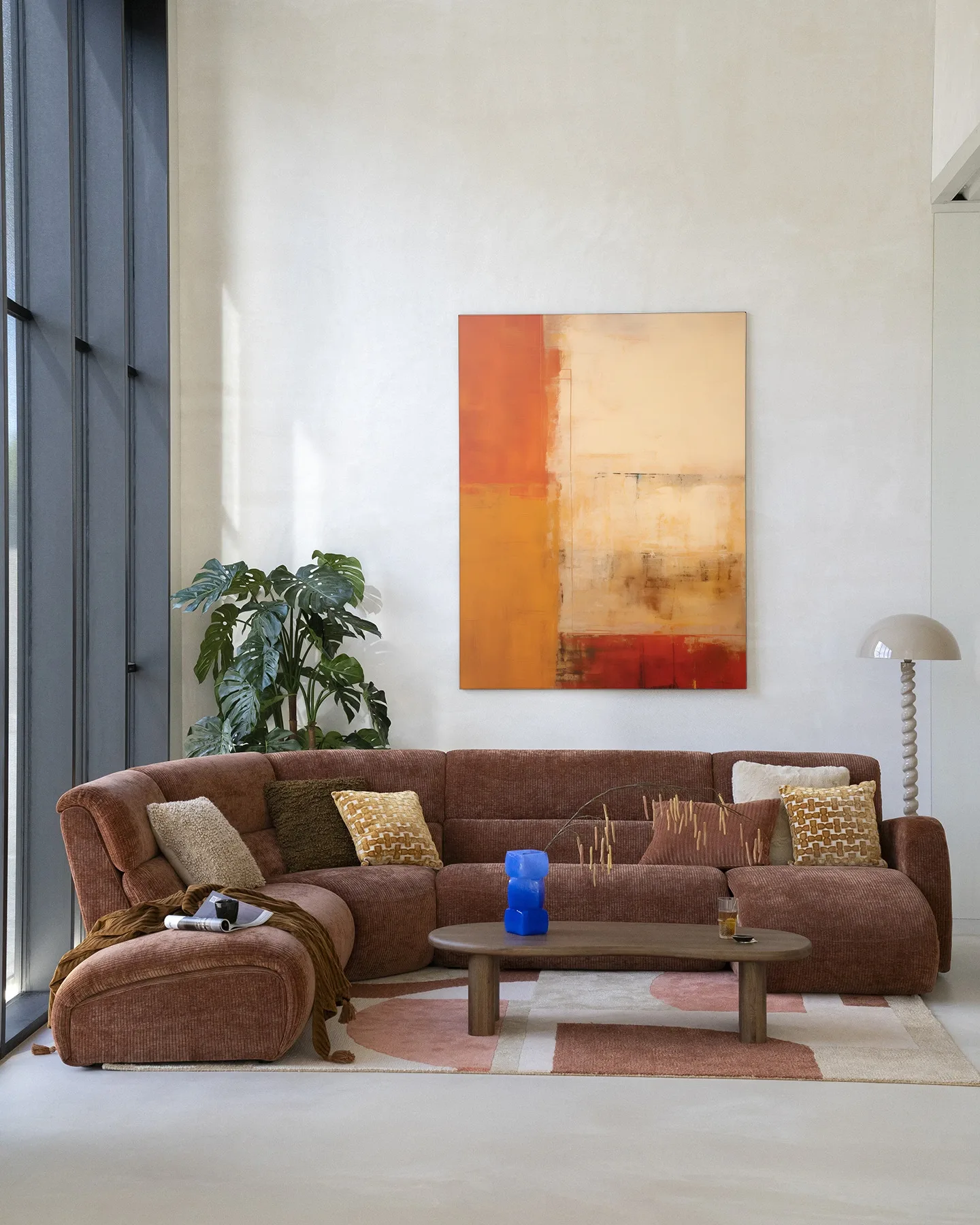 Wandteppich Rusty Abstract von Urban Cotton hängt über einem braunen Sofa in einem hellen Wohnzimmer