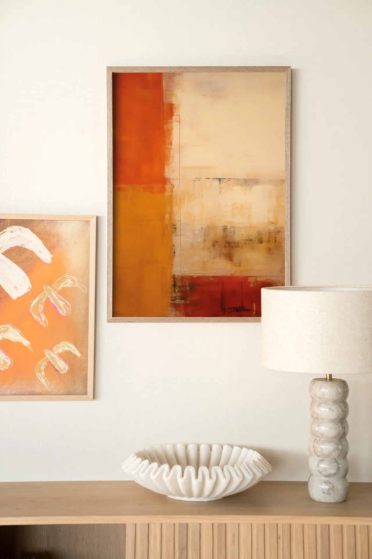 Wandteppich Rusty Abstract - Urban Cotton hängt über einem Holzschrank mit einer Lampe und Schale