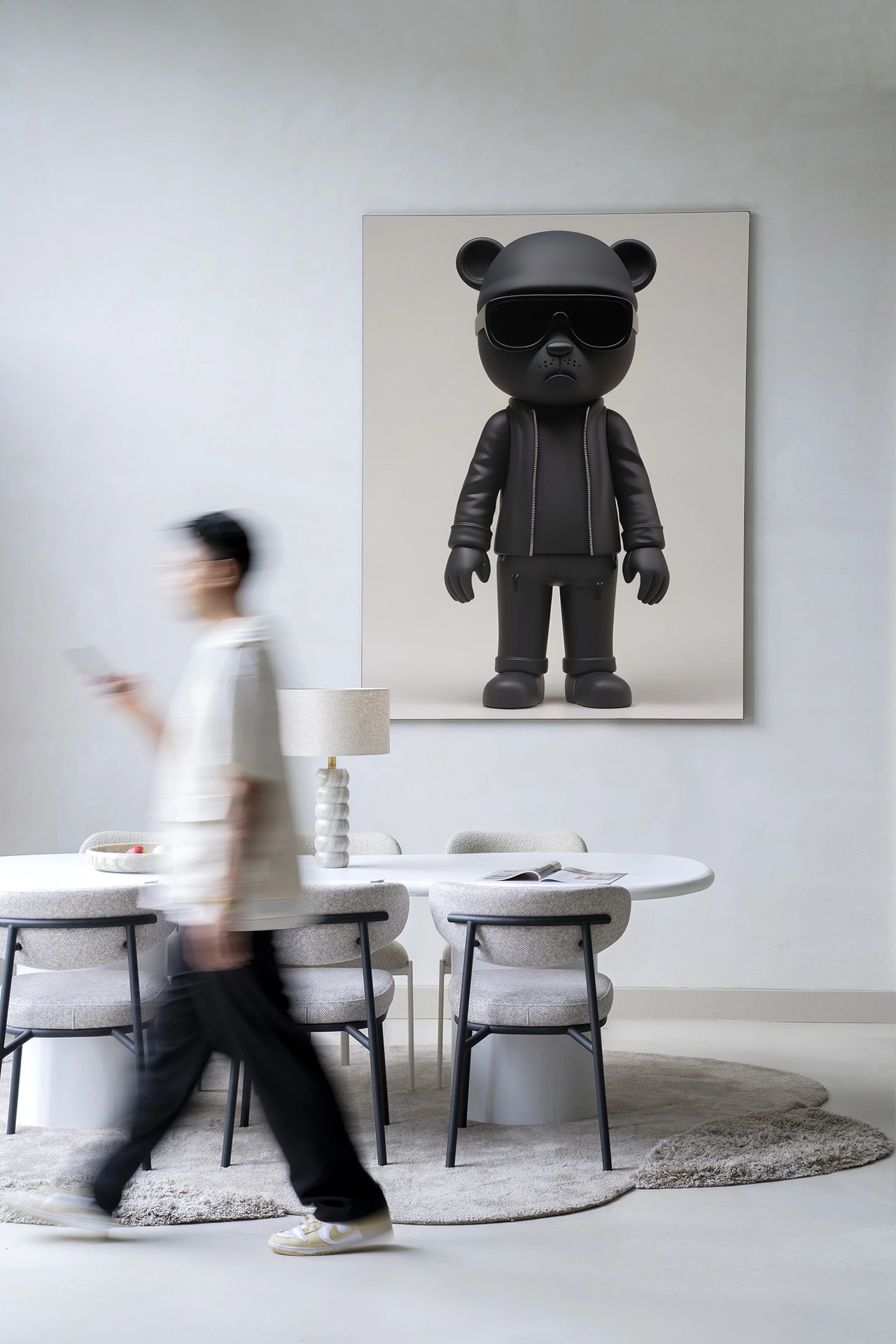 Wandteppich Security Bear - Urban Cotton hängt an einer weißen Wand über einem Esstisch mit Stühlen