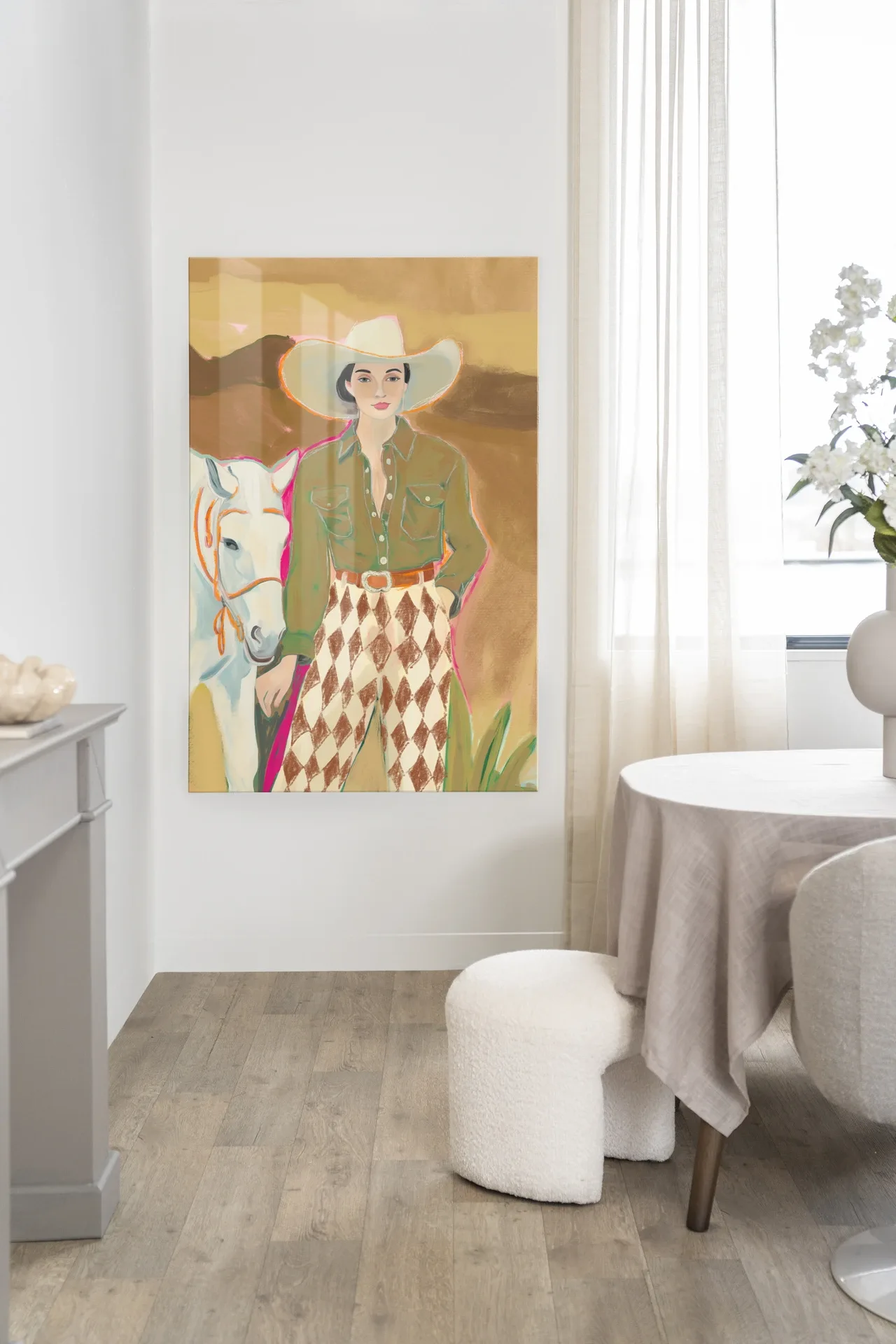 Wandteppich Cowgirl 3 hängt an einer weißen Wand in einem hellen Esszimmer mit einem weißen Pouf - Urban Cotton