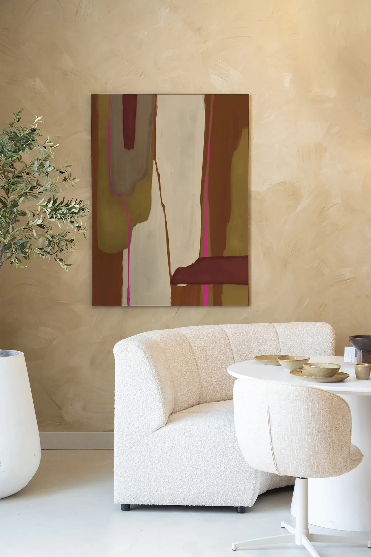 Wandteppich Zafra von Urban Cotton hängt an einer Wand mit beiger, wischartiger Textur, über einem weißen Sofa und Tisch