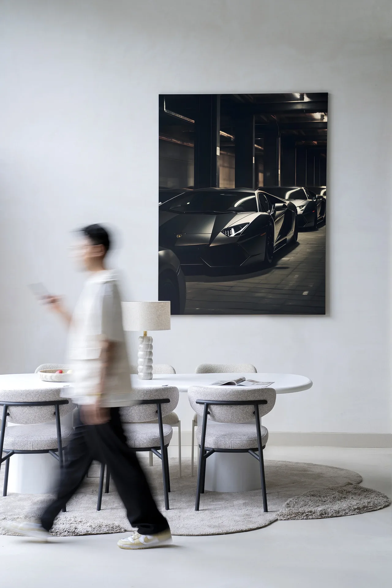 Wandteppich Luxury Drive - Urban Cotton hängt an einer weißen Wand in einem modernen Interieur, eine Person geht vorbei