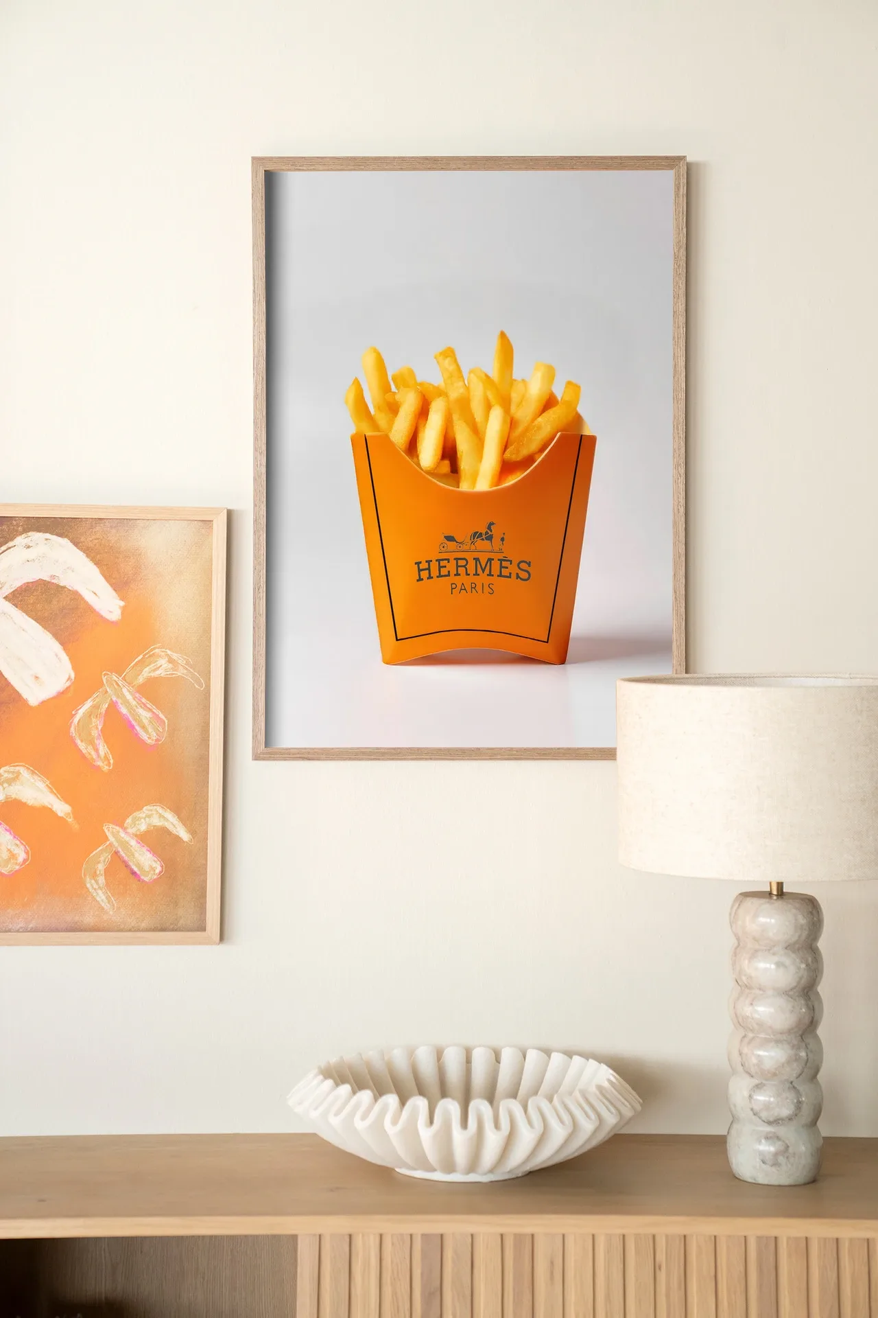 Wandteppich Hermes Fries - Urban Cotton hängt über einem Holzschrank mit Lampe und Schale
