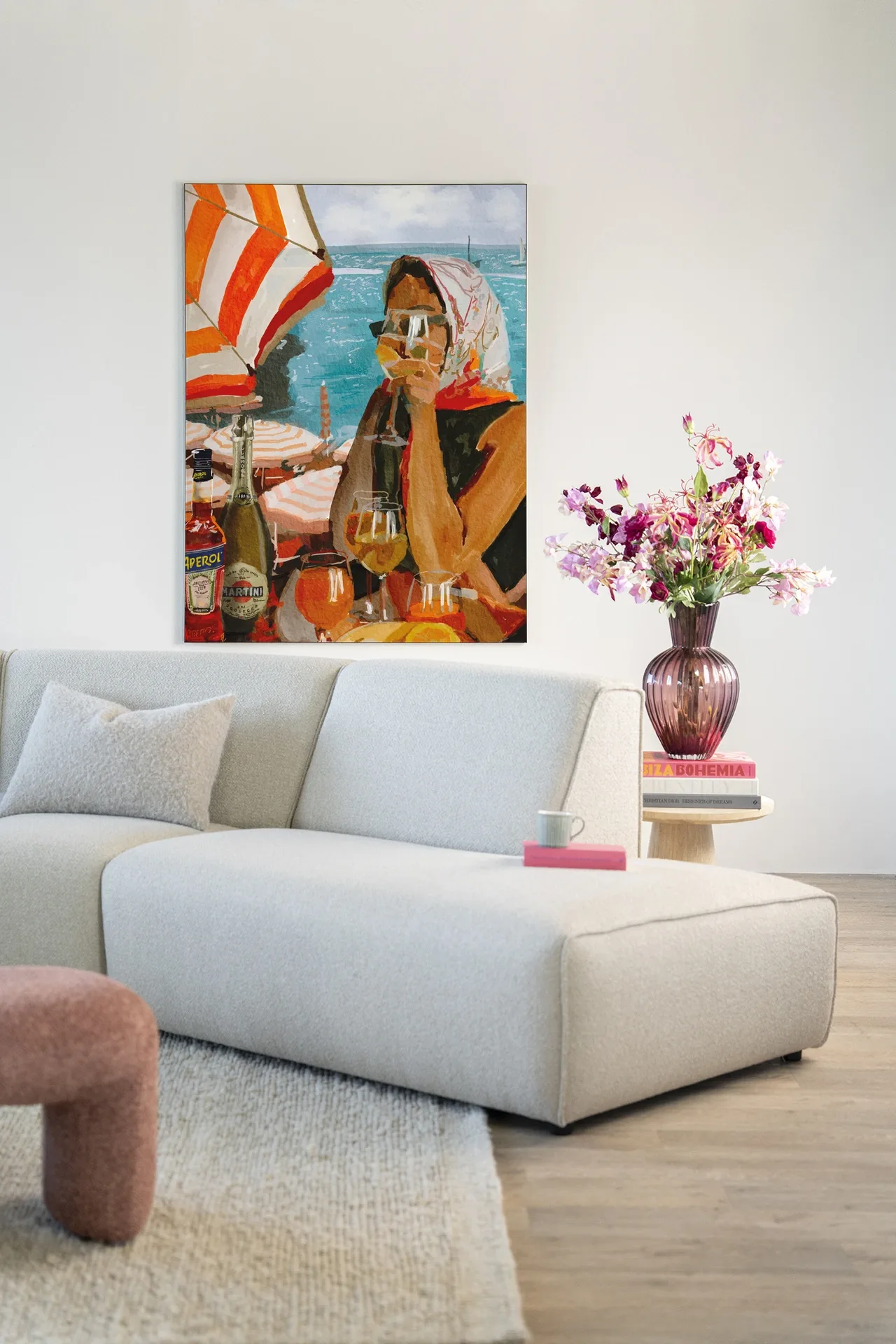 Wandteppich Aperol o'clock - Urban Cotton hängt über einem hellen Sofa in einem modernen Wohnzimmer