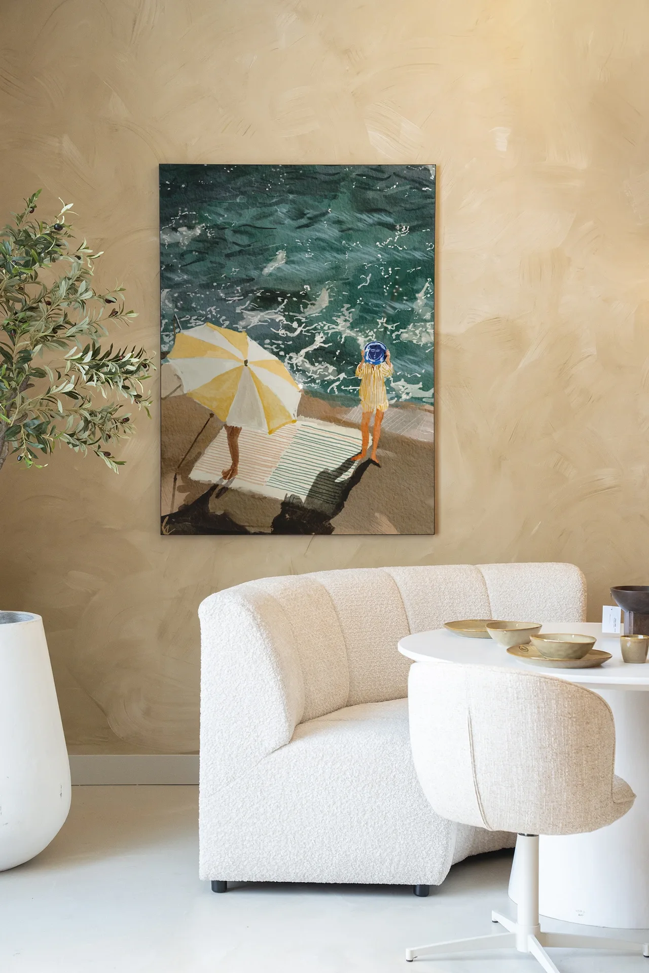 Wandteppich Between The Sun And Storm - Urban Cotton hängt an einer Wand über einem cremefarbenen Sofa und einem weißen Tisch
