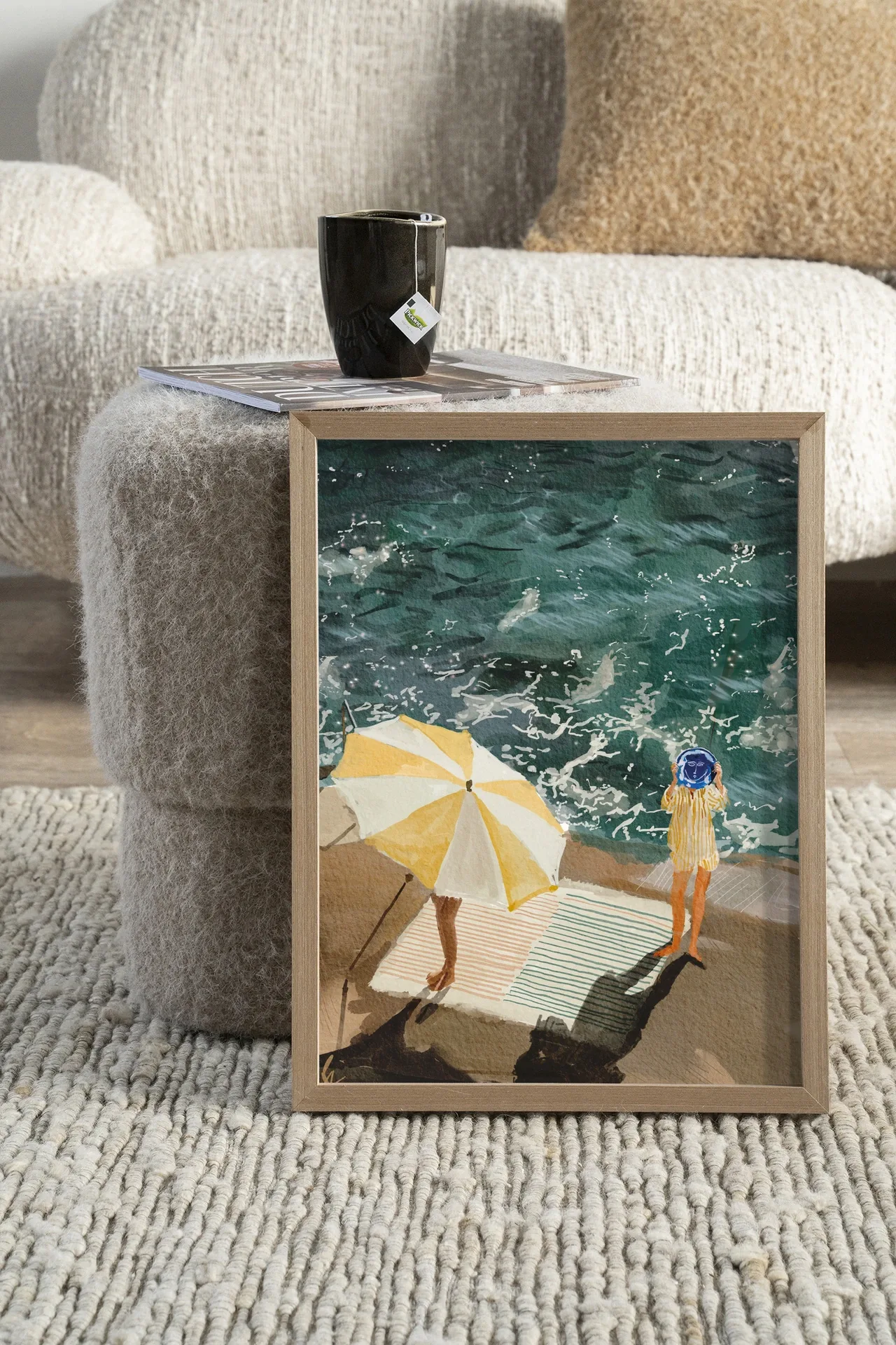 Wandteppich Between The Sun And Storm - Urban Cotton in einem Wohnzimmer auf einem Hocker mit einer Tasse