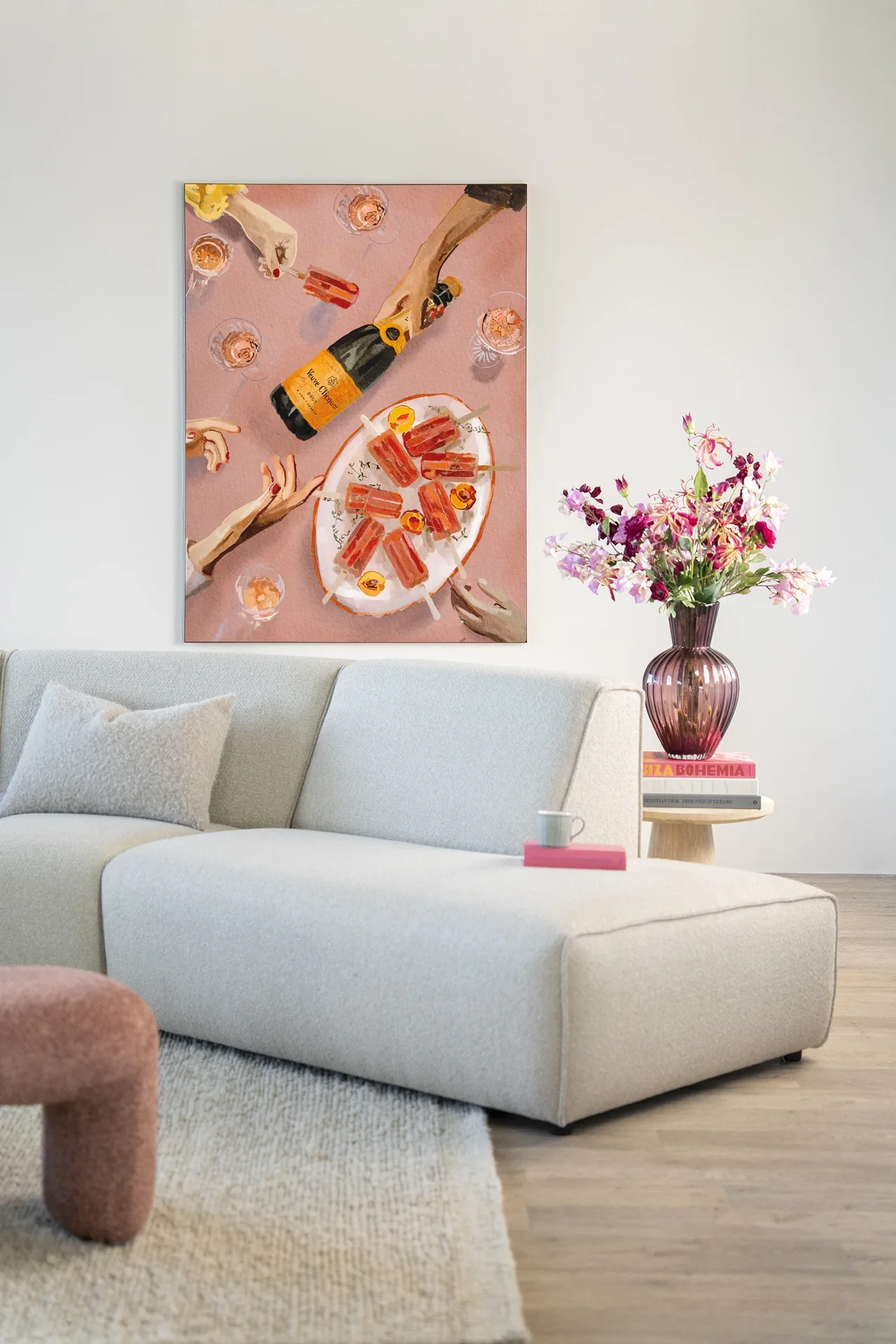 Wandteppich Champagne And Icecreams - Urban Cotton hängt über einem hellen Sofa mit einer Blumenvase daneben