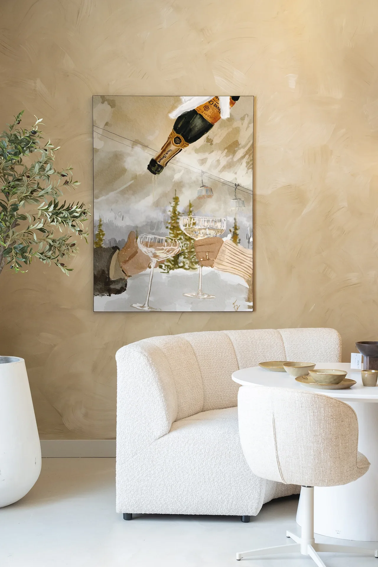 Ein Wandteppich Winter Champagne von Urban Cotton hängt über einem cremefarbenen Sofa und einem weißen Tisch