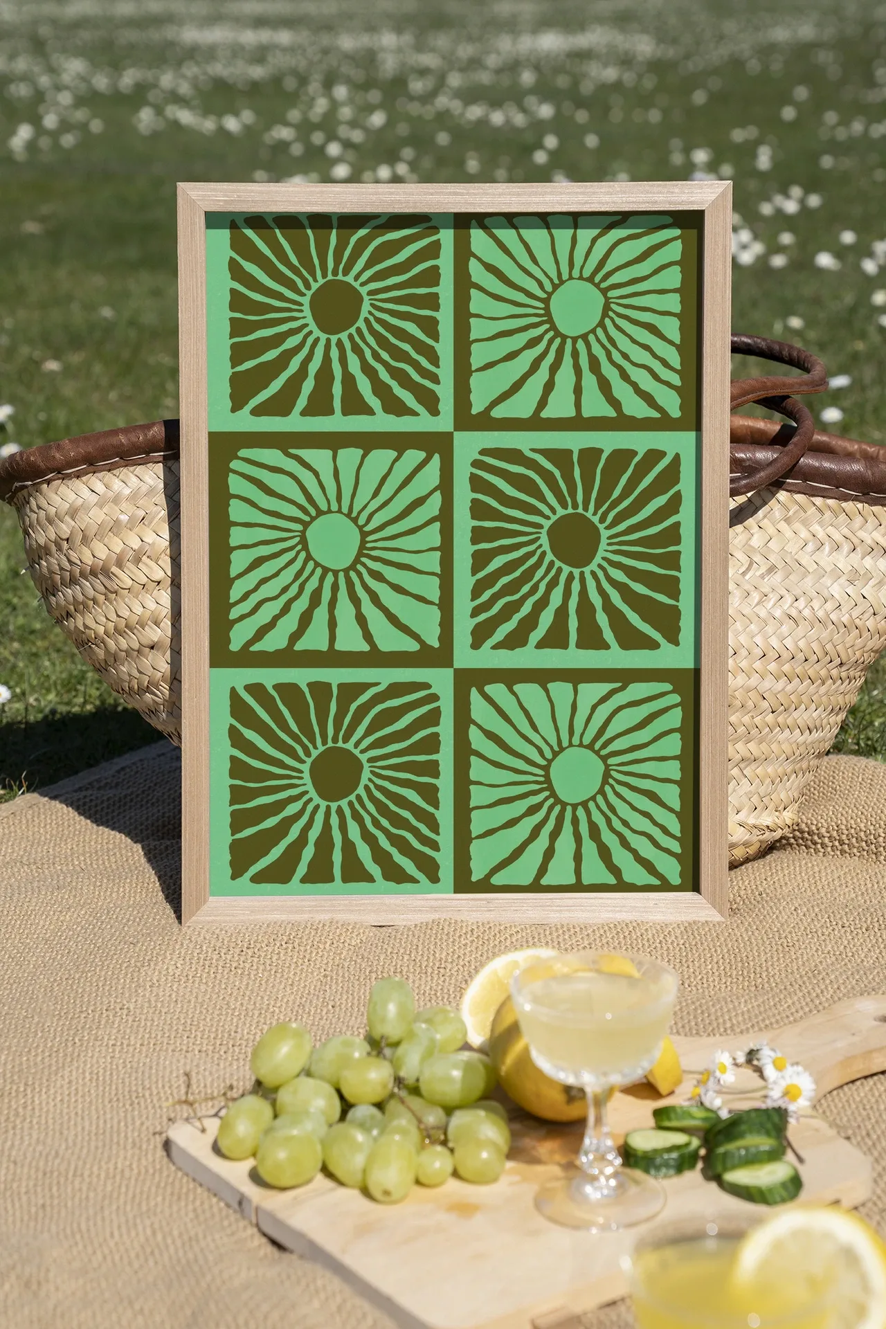 Wandteppich Suns In Green - Urban Cotton in einem Holzrahmen auf einer Picknickdecke mit Obst und Getränken