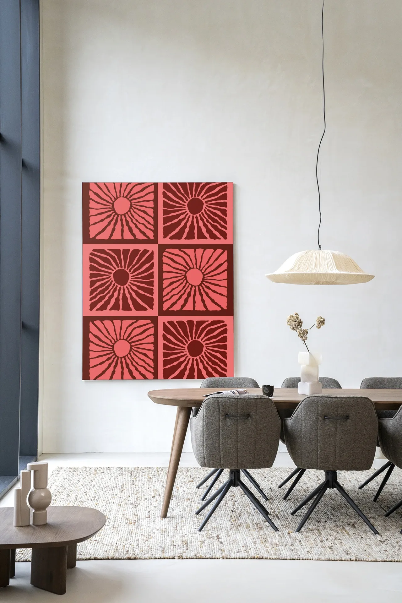Wandteppich Suns In Pink - Urban Cotton hängt an einer weißen Wand über einem Esstisch mit Stühlen