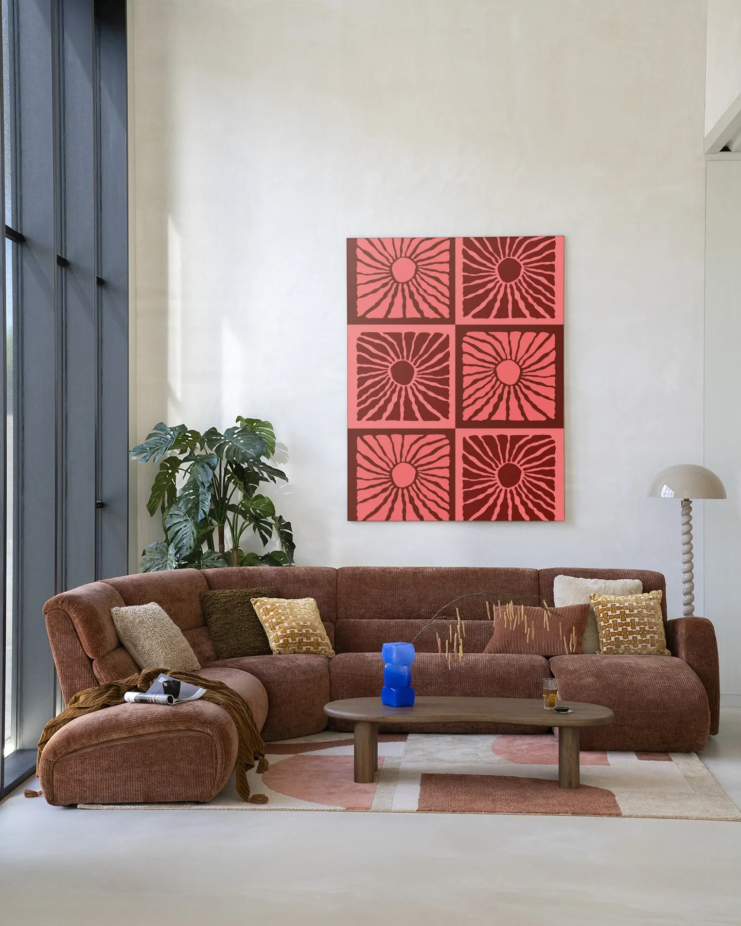 Wandteppich Suns In Pink - Urban Cotton hängt über einem braunen Sofa in einem modernen Wohnzimmer