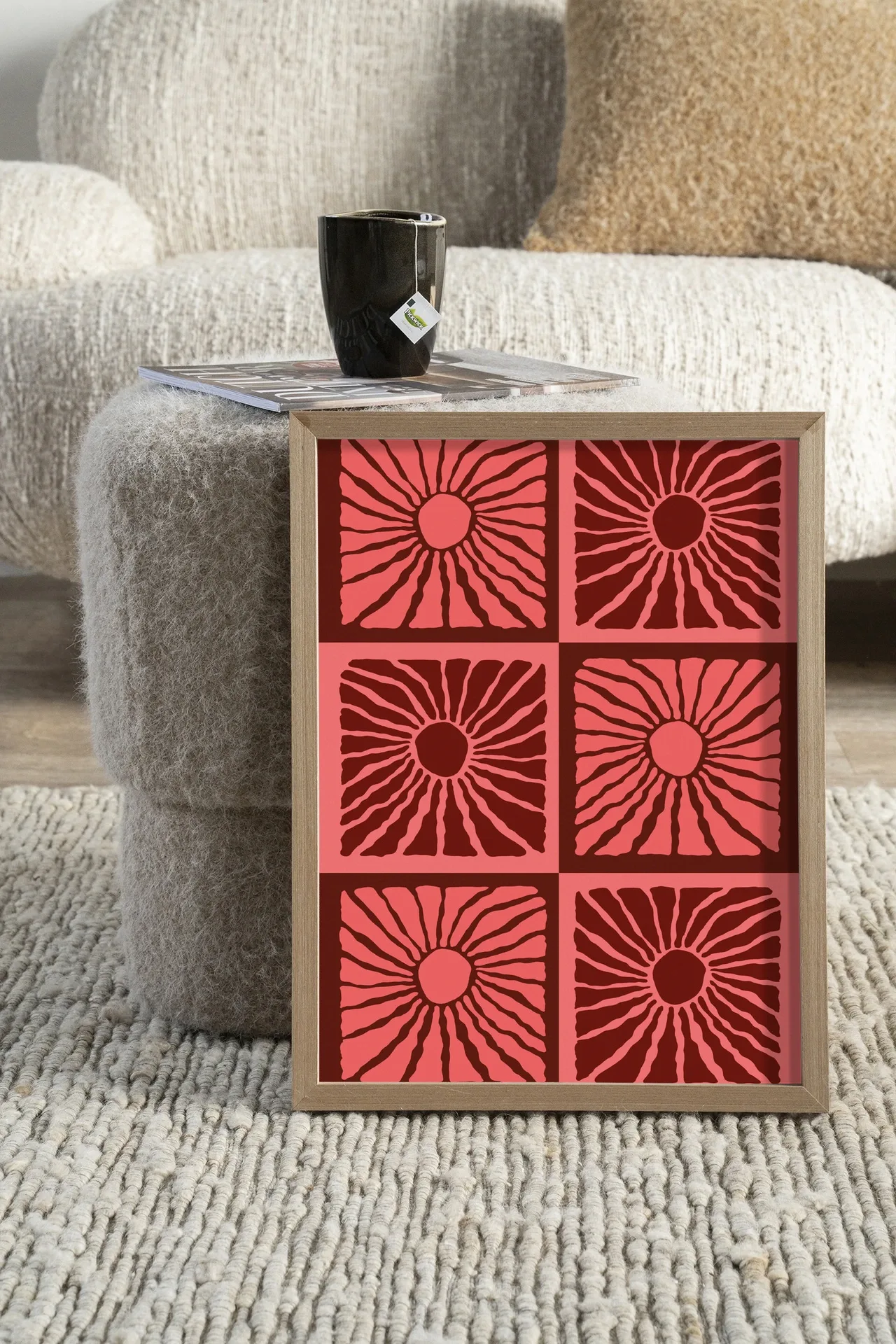 Wandteppich Suns In Pink - Urban Cotton in einem Holzrahmen, stehend auf einem cremefarbenen Teppich