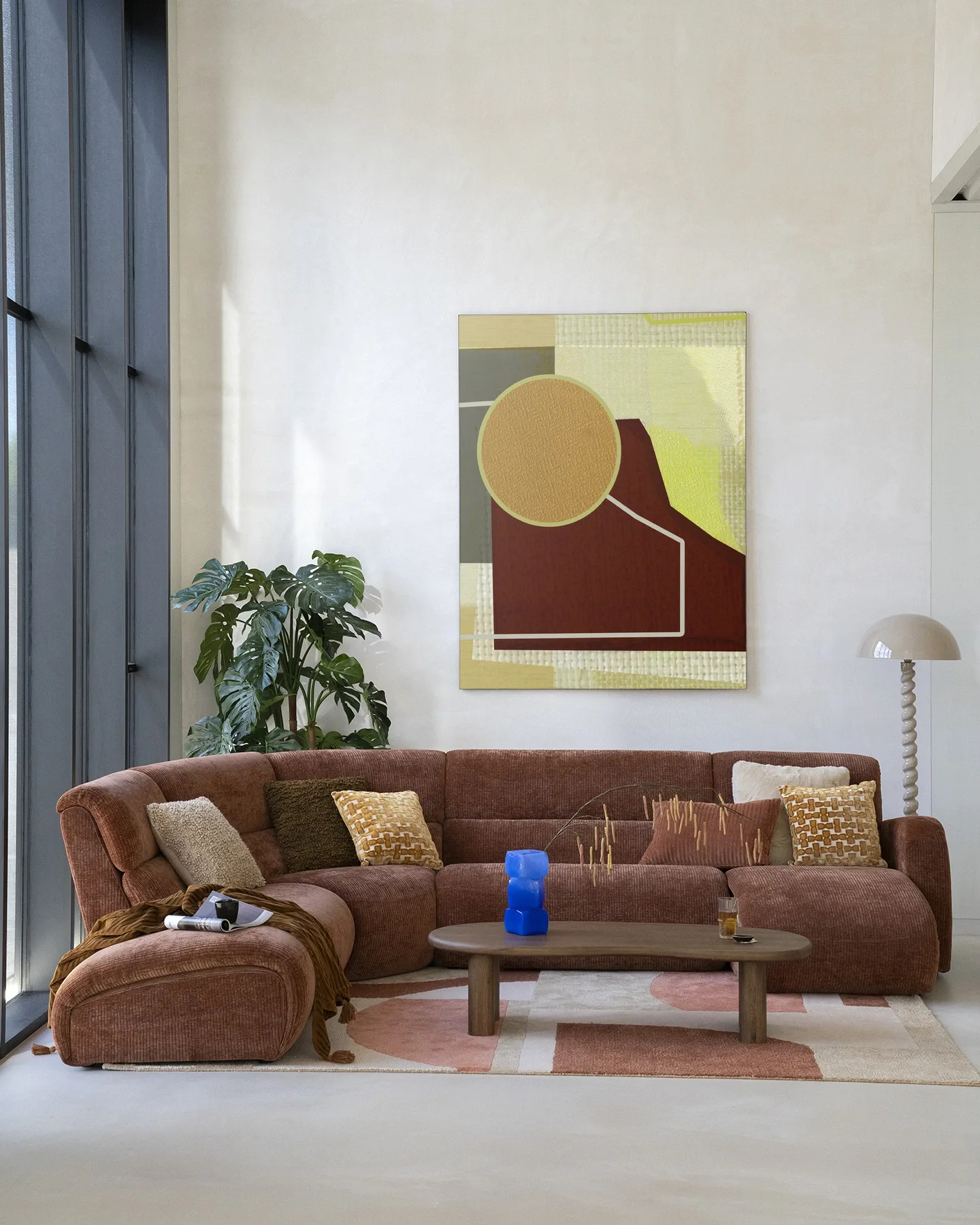 Der Wandteppich Bounce - Urban Cotton hängt über einem braunen Cordsofa in einem hellen Wohnzimmer