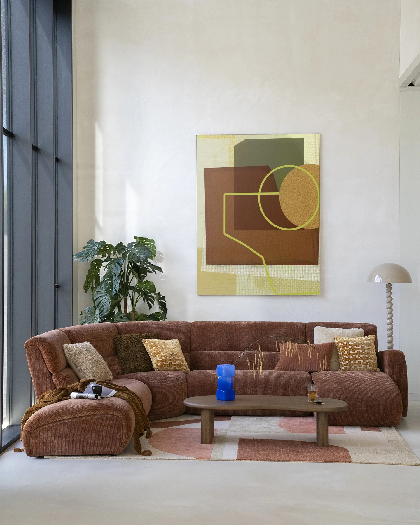 Wandteppich Rally von Urban Cotton hängt über einem braunen Sofa in einem modernen Wohnzimmer