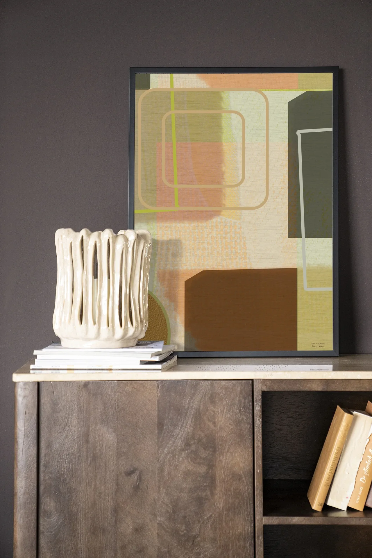 Wandteppich Serve - Urban Cotton hängt über einem Holzsideboard mit einer Vase und Büchern