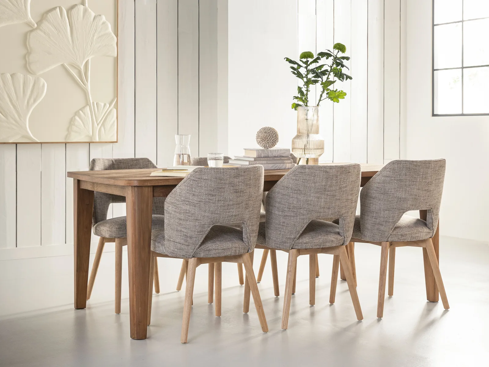 Esstisch Bliss in einem Esszimmer mit sechs gepolsterten Stühlen, dekoriert mit Büchern und Vasen - DTP Home