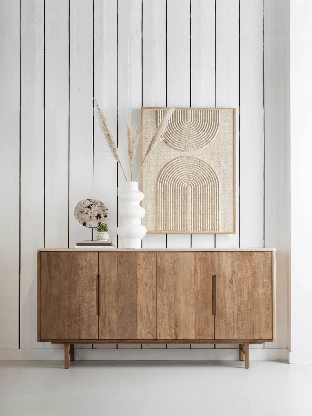 Dressoir Bliss 2 in een lichte studio met witte plankenwand, gedecoreerd met vazen en kunst - DTP Home