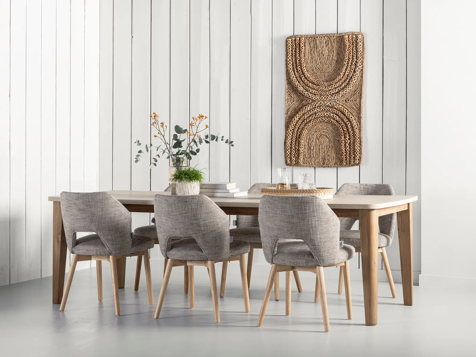 Esstisch Bliss 2 mit sechs gepolsterten Stühlen in einem Studio mit weißer Holzwand und Dekoration - DTP Home