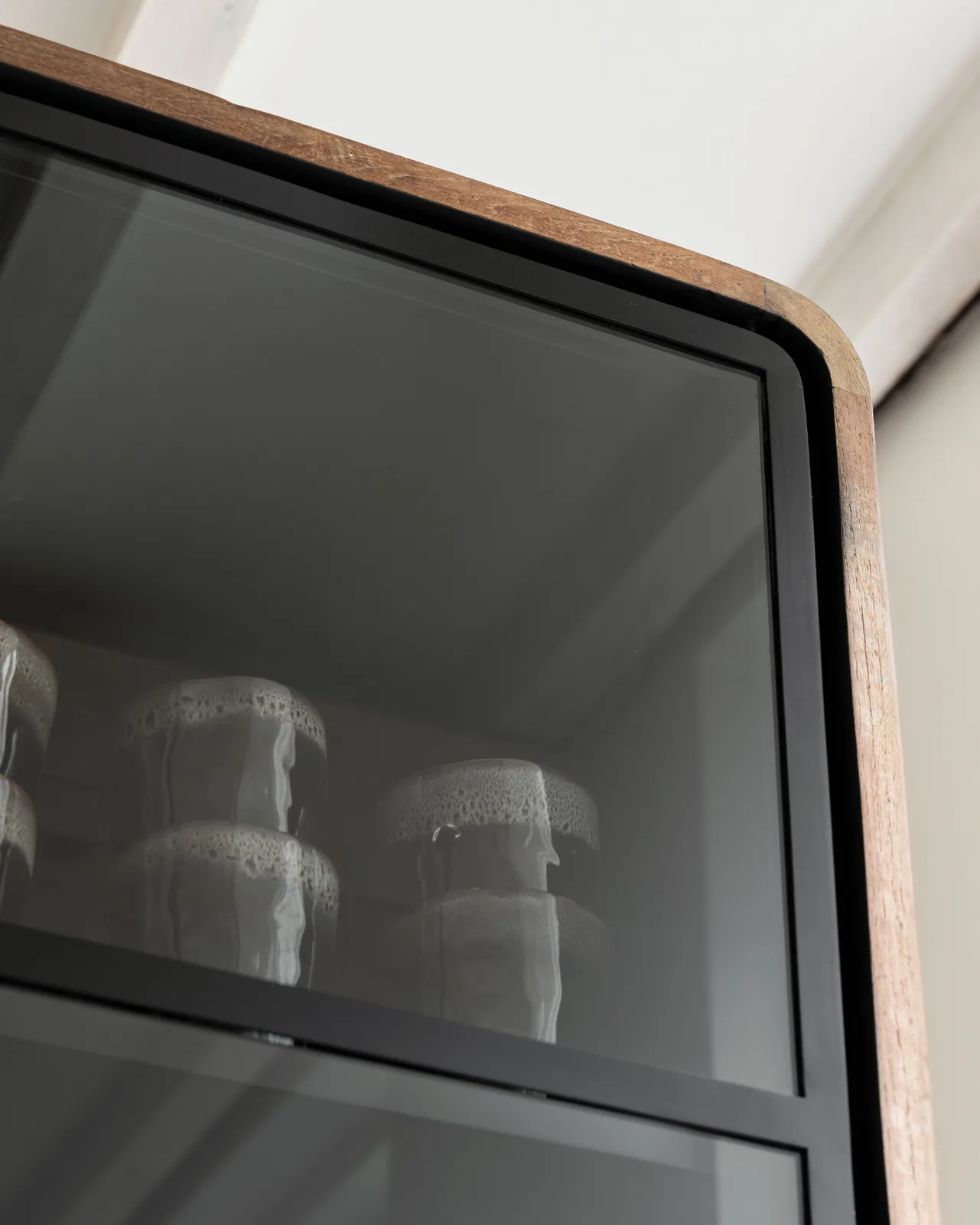 Close-up van de Vitrinekast Evo met een glazen deur en een houten frame, met servies erin - DTP Home