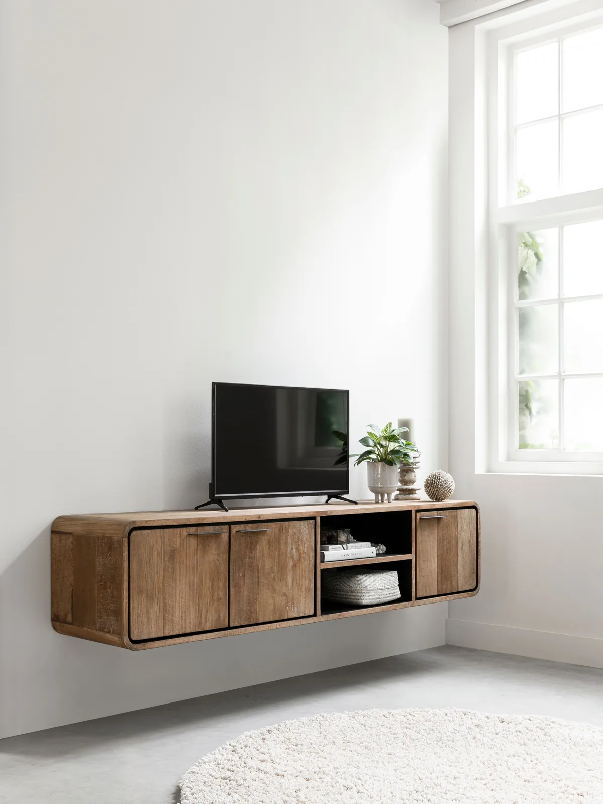 TV-Möbel Evo schwebend in einem hellen Wohnzimmer mit Fernseher, Pflanze und Dekoration - DTP Home