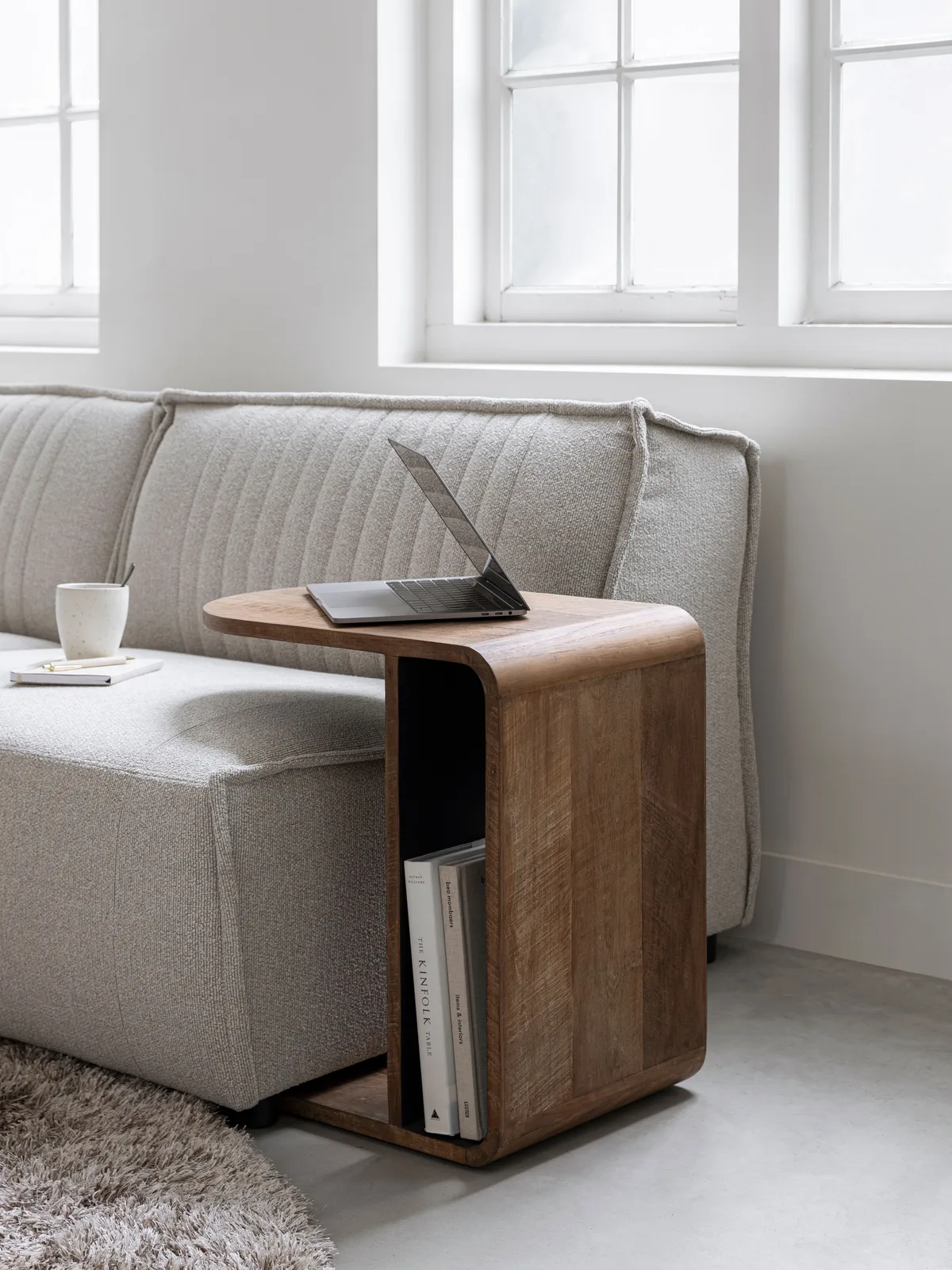 Laptoptisch Evo in einem hellen Wohnzimmer mit Laptop und Tasse auf der Platte, neben einem Sofa - DTP Home