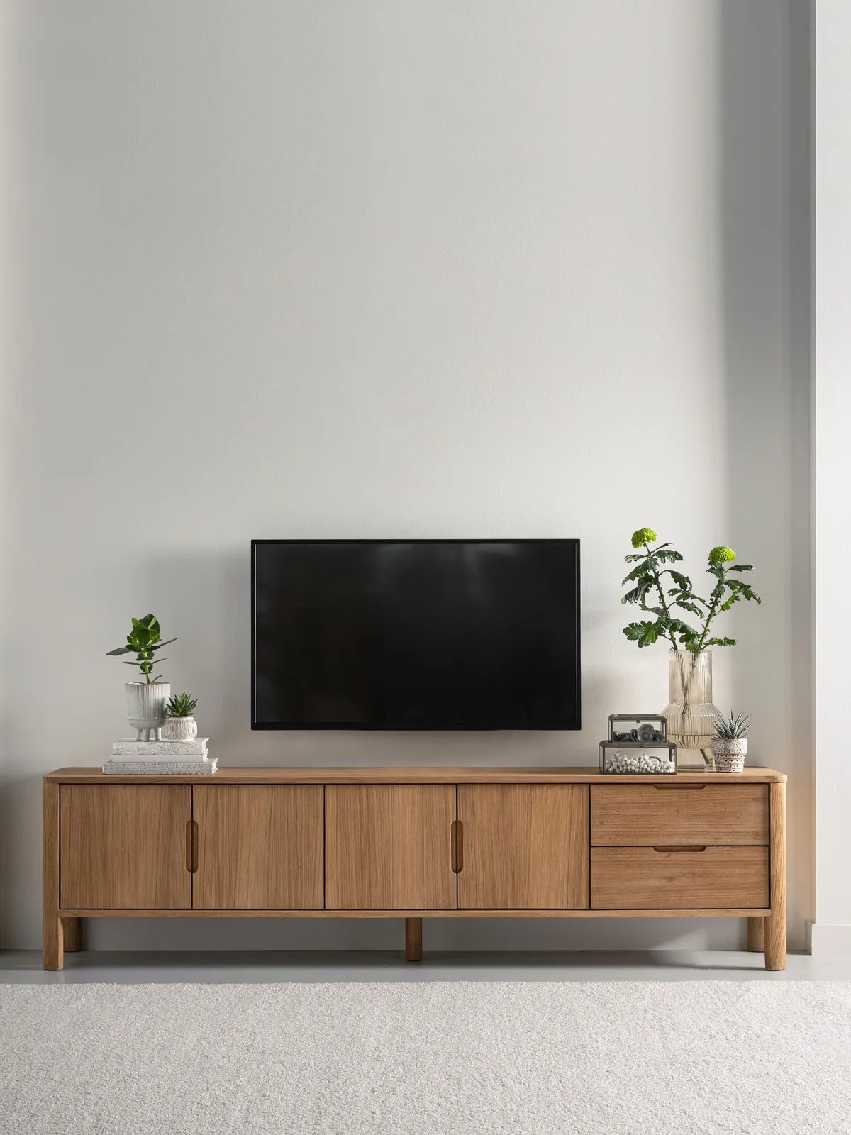 Tv-Möbel Forte in einer modernen Studio-Umgebung, mit Pflanzen und einem Fernseher darüber - DTP Home