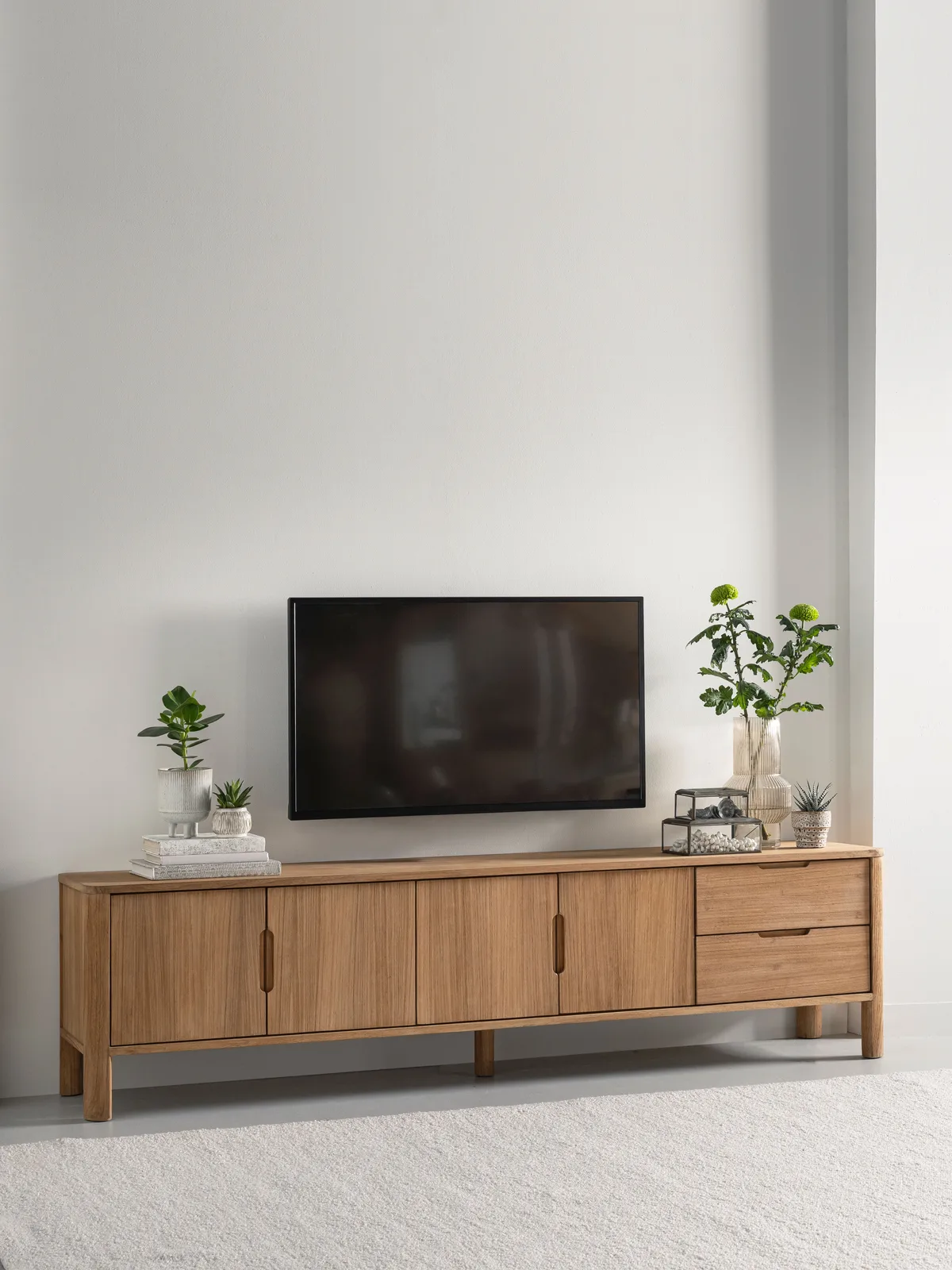 Tv-meubel Forte in een lichte studio met een televisie erboven en decoratie erop - DTP Home