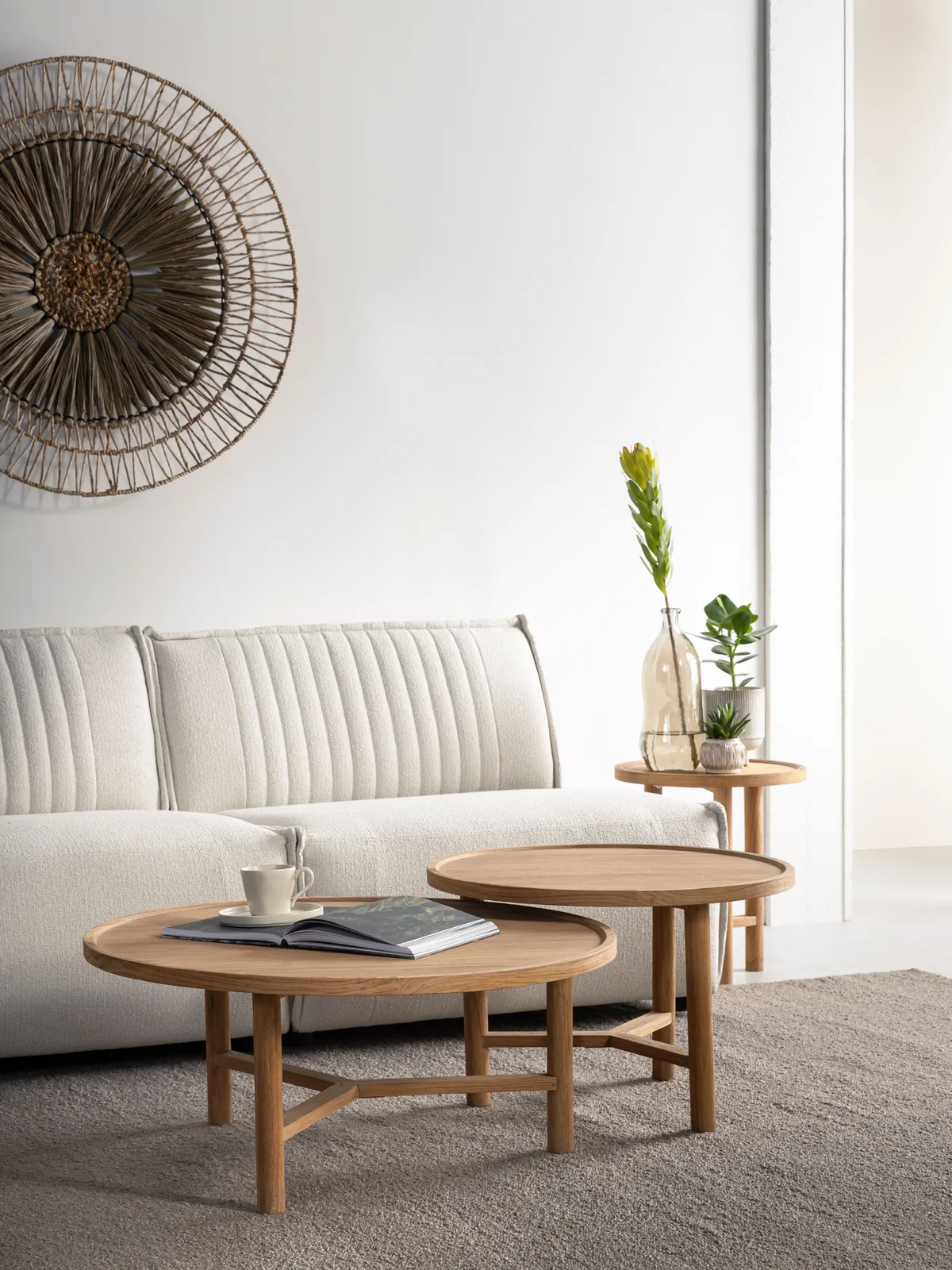 Der runde Couchtisch Forte in einem hellen Wohnzimmer mit Sofa und Dekoration - DTP Home