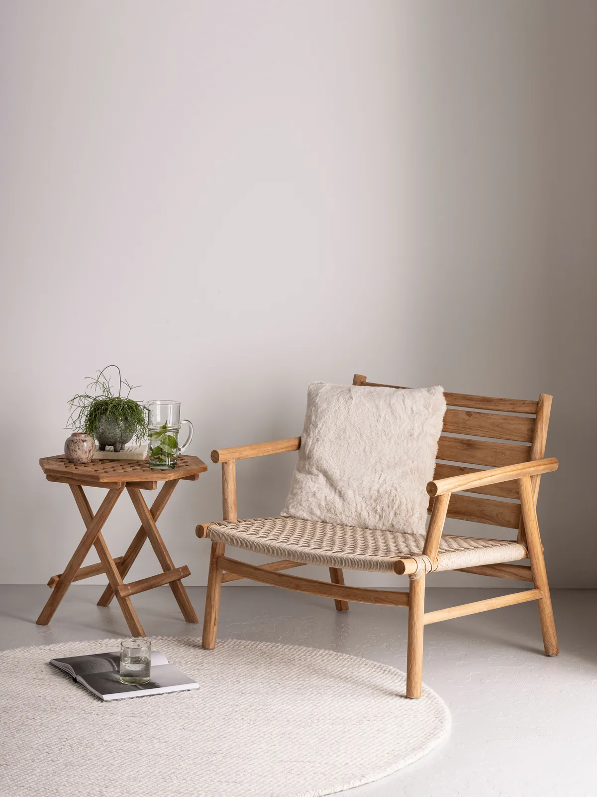 Loungesessel Ono in einer hellen Studio-Umgebung mit einem Beistelltisch, Pflanze und rundem Teppich - MUST Living