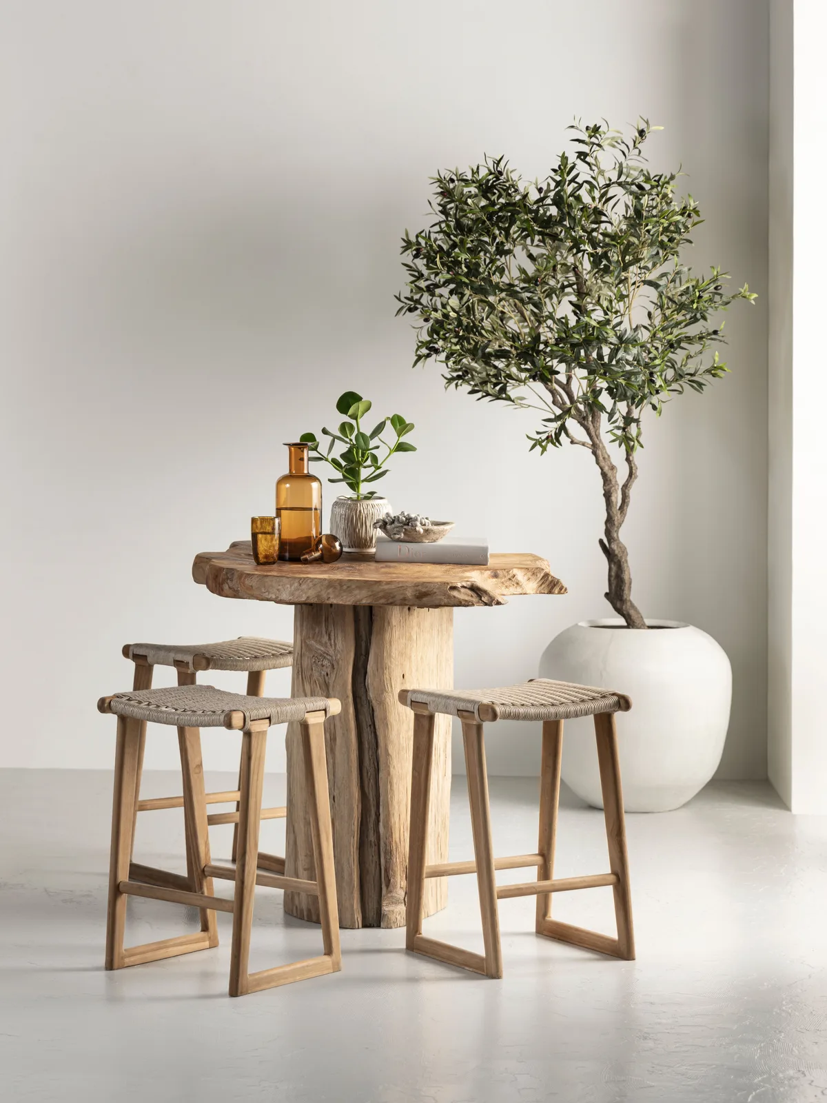 Gartenstuhl Kento in einer hellen Studio-Umgebung mit einem Holztisch und einem Olivenbaum - MUST Living
