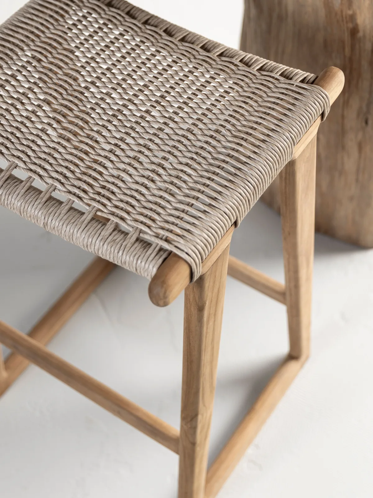 Detailaufnahme der Sitzfläche und Beine des Gartenstuhls Kento, mit geflochtenem Muster und Holzrahmen - MUST Living