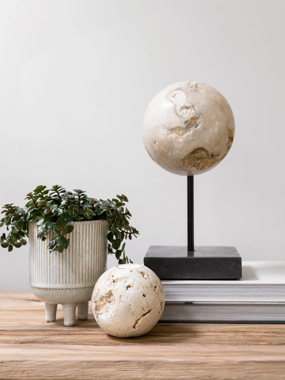 Schilderij Ball Cheese Stone op een houten plank met een plant en boeken, witte achtergrond - MUST Living