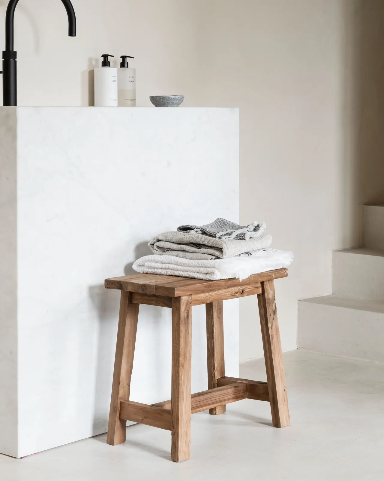 Hocker Easy rechteckig mit Handtüchern in einem Badezimmer mit weißen Wänden und einem schwarzen Wasserhahn - MUST Living
