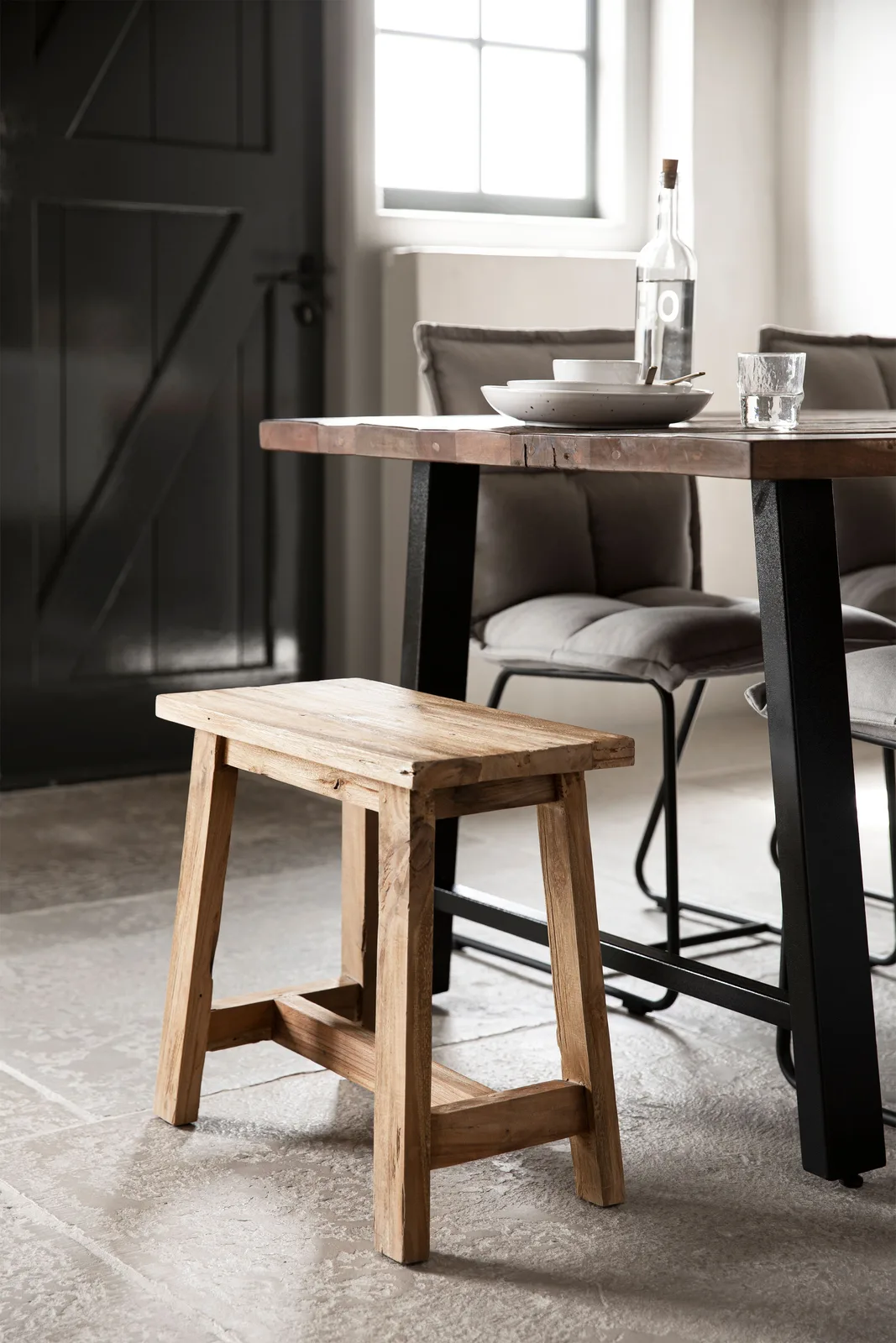 Der rechteckige Hocker Easy in einem Esszimmer mit einem Holztisch und Stühlen mit grauen Kissen - MUST Living