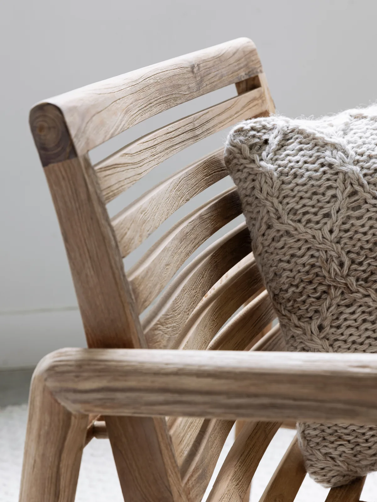 Detailaufnahme des Loungestoel Ray mit einem gestrickten Kissen, von der Seite gesehen - MUST Living