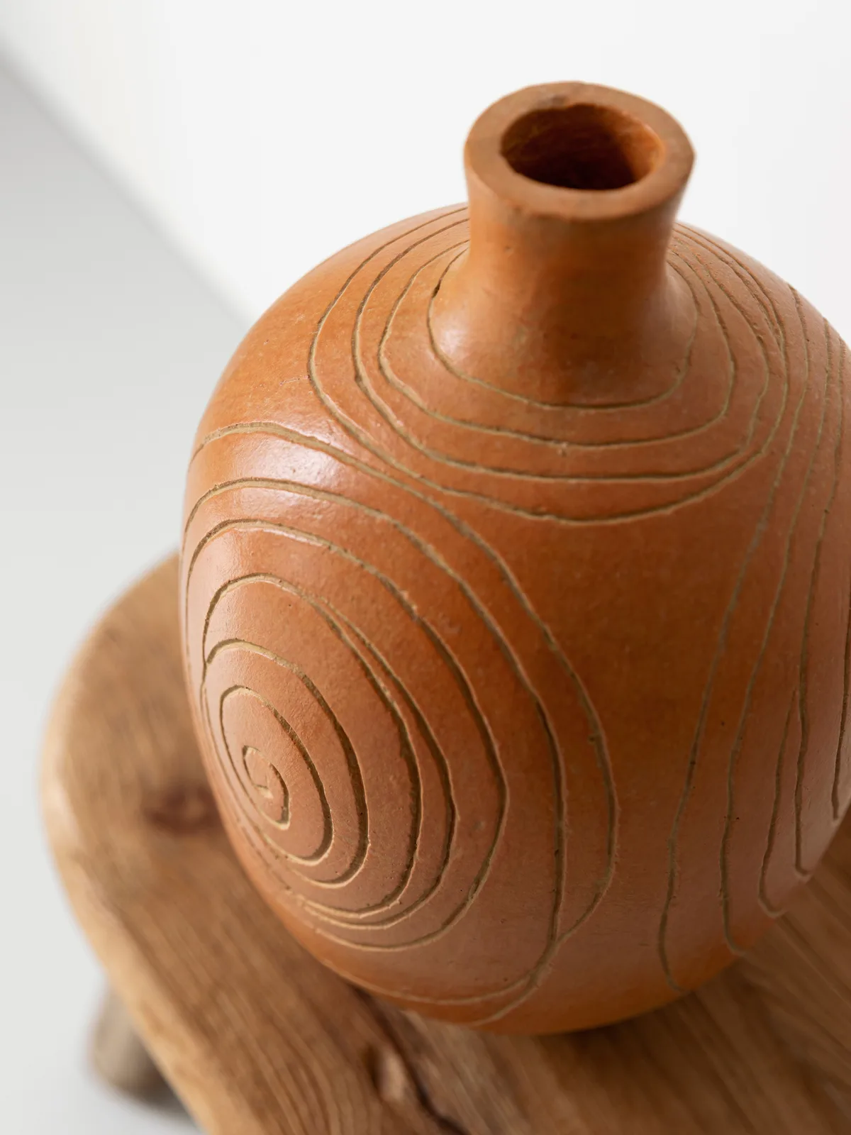 Nahaufnahme der Vase Lisbon, einer Terrakottavase mit spiralförmigen Rillen, auf einem Holzuntergrund - MUST Living
