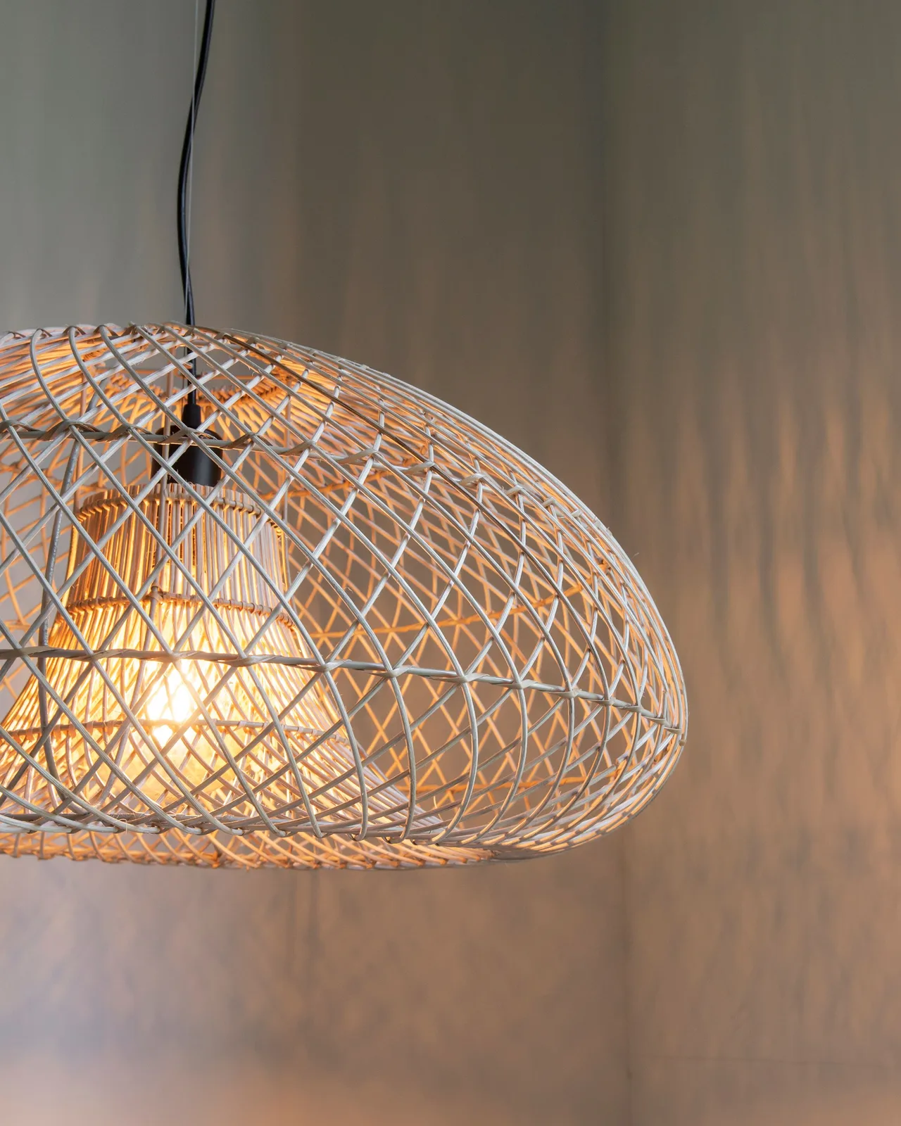 Nahaufnahme der Hängeleuchte Pendant lamp Cala Salada small mit einer glühenden Lampe in dunkler Umgebung - MUST Living