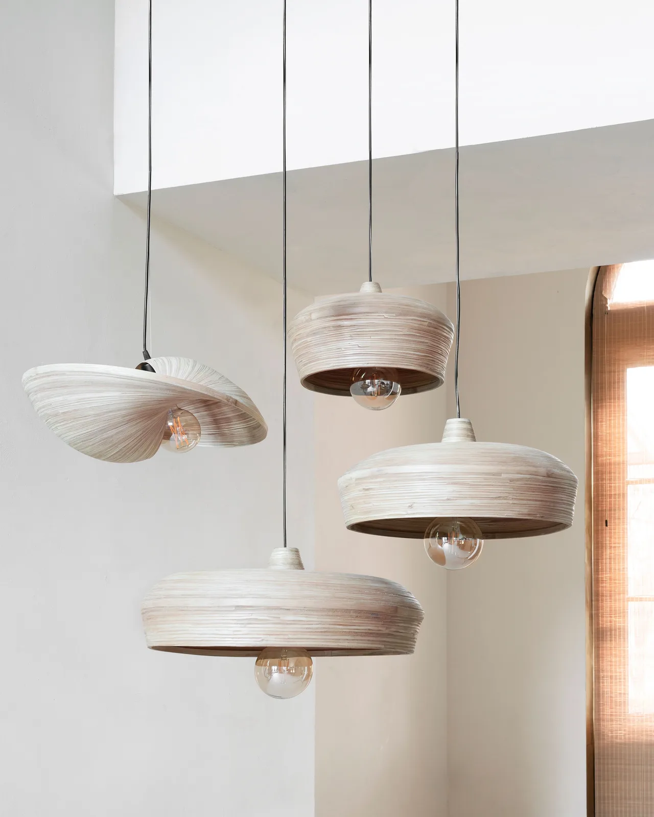 Vier Malakka hanglampen in verschillende vormen hangen aan het plafond in een lichte ruimte - MUST Living