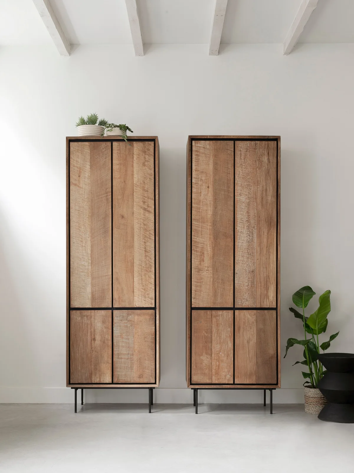 Twee hoge kasten Metropole met houten deuren en zwarte frames in een lichte studio - DTP Home