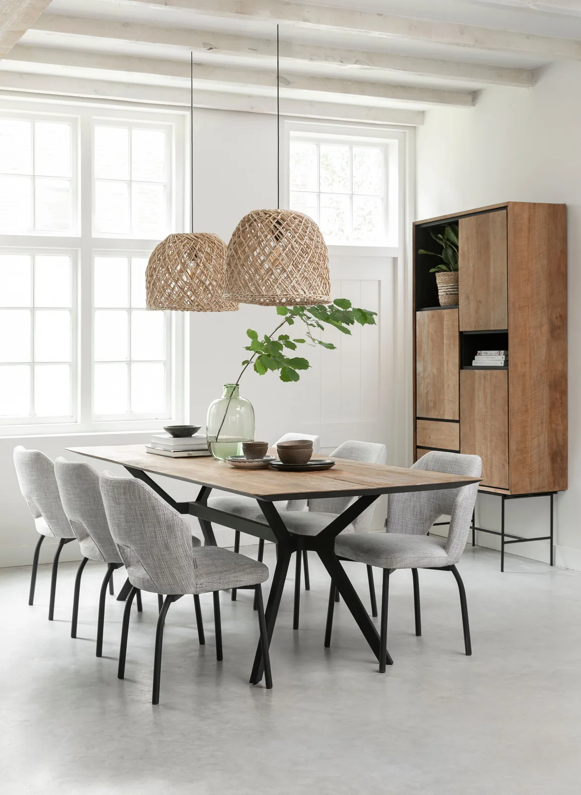Bücherregal Metropole hoch in einem hellen Esszimmer mit Holztisch, Stühlen und Rattanlampen - DTP Home