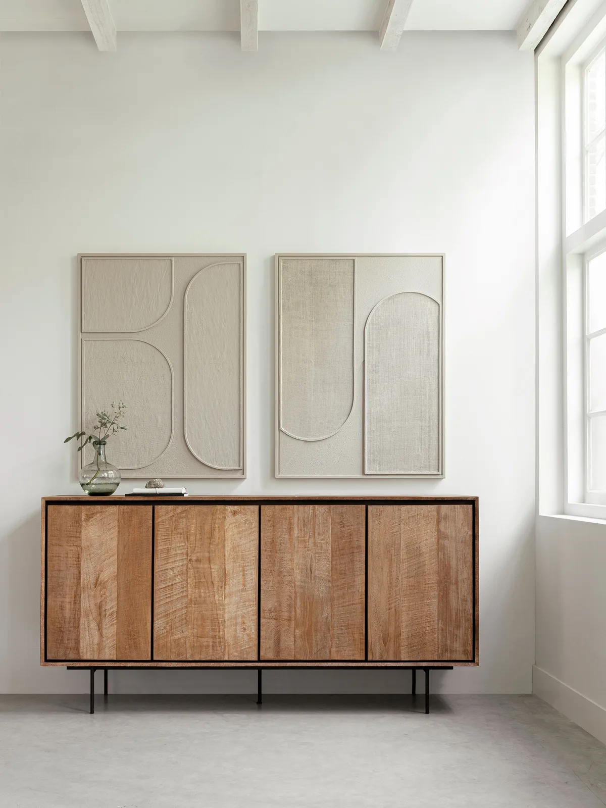 Sideboard Metropole in einem hellen Wohnzimmer mit zwei abstrakten Kunstwerken darüber - DTP Home