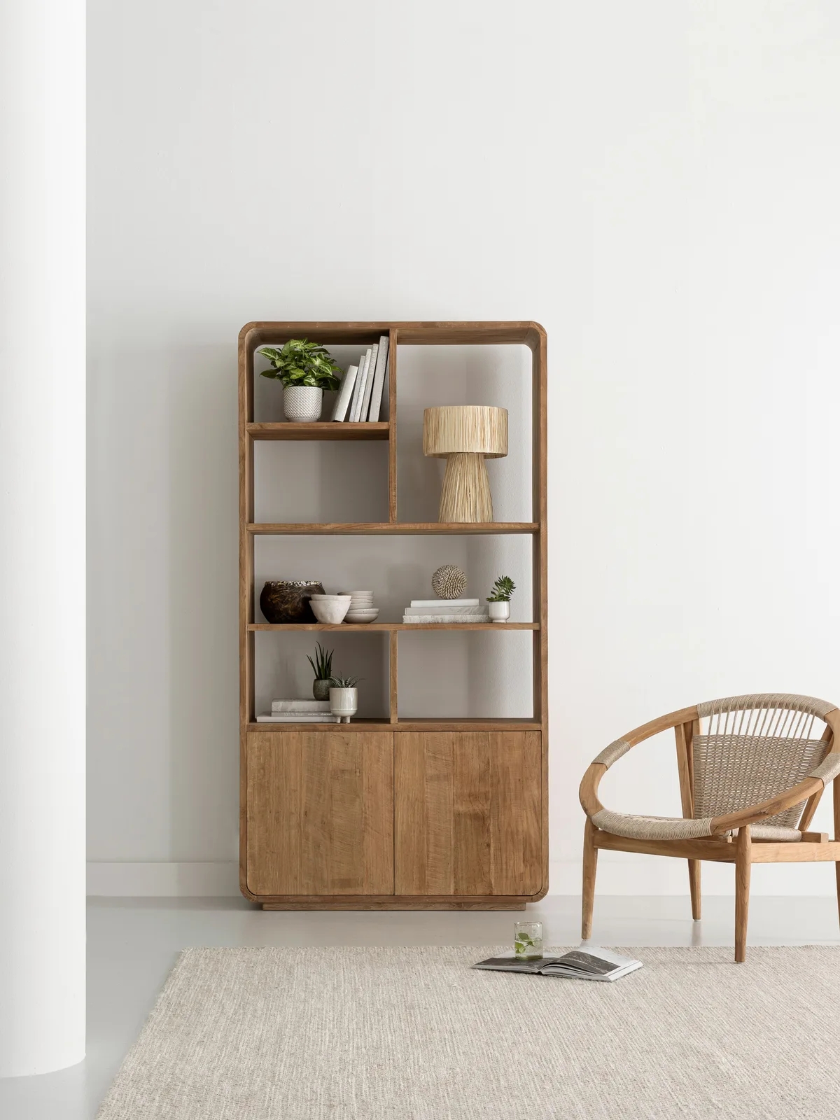 Bücherregal Nova klein in einem hellen Wohnzimmer mit einem Sessel und Teppich - DTP Home