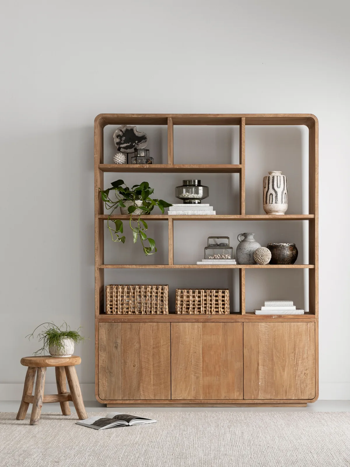 Boekenkast Nova klein in een lichte woonkamer met decoratie en een krukje ernaast - DTP Home